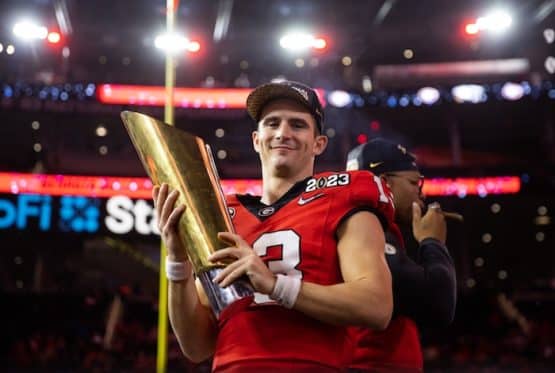 Georgia Bulldogs quarterback Stetson Bennett holds a trophy.