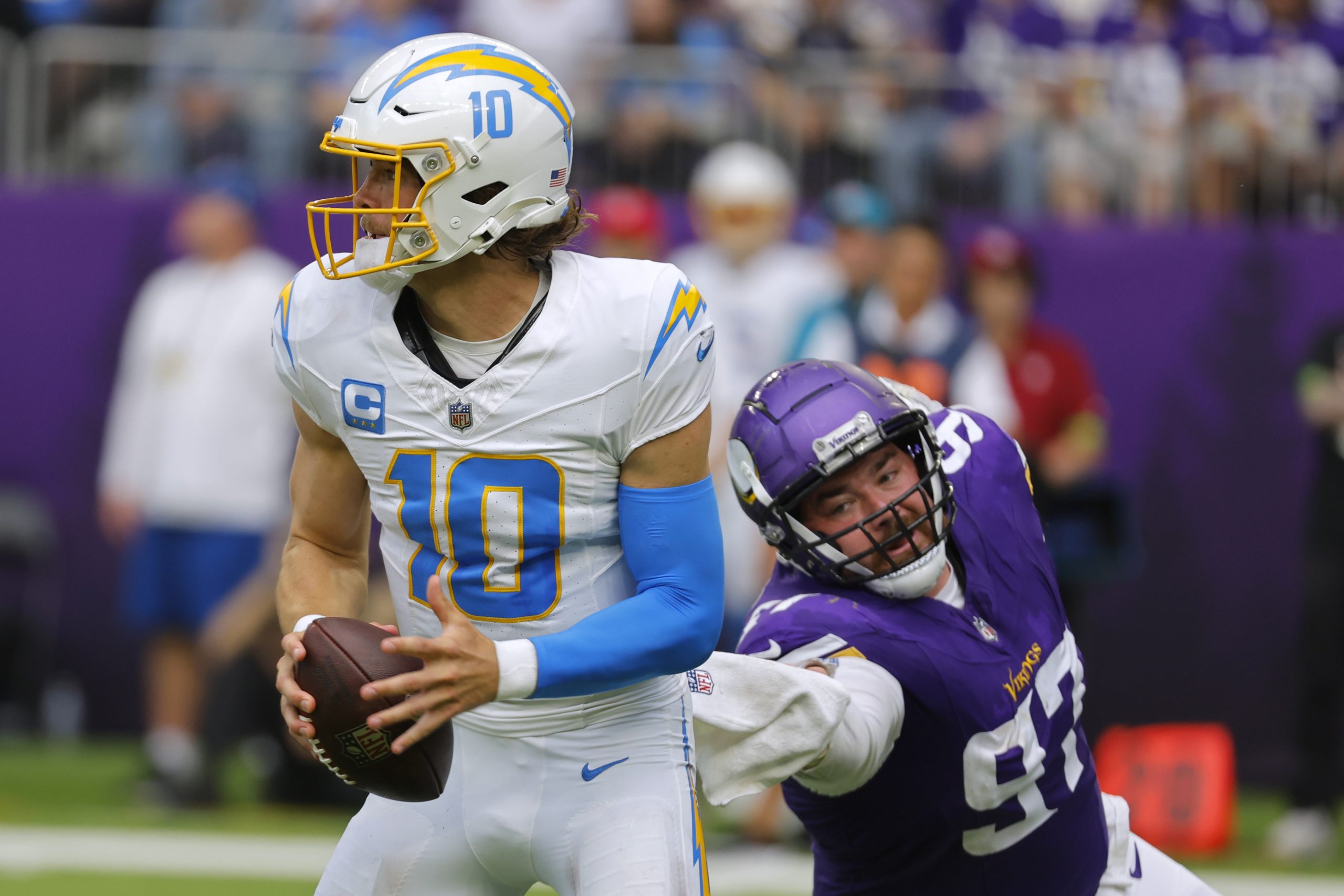 Los Angeles Chargers quarterback Justin Herbert runs from Minnesota Vikings...