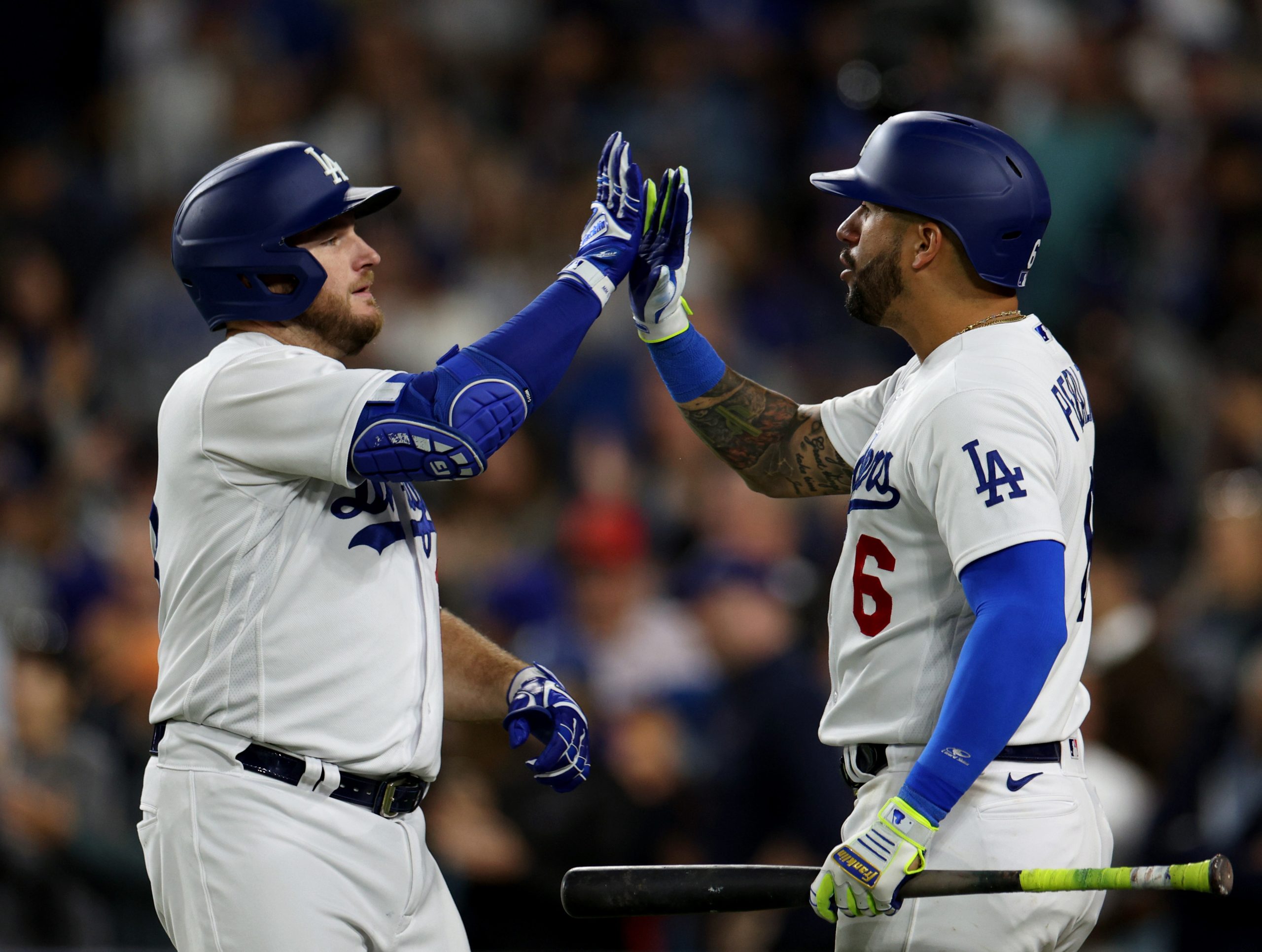 The Dodgers’ Max Muncy, left, celebrates with teammate David Peralta...