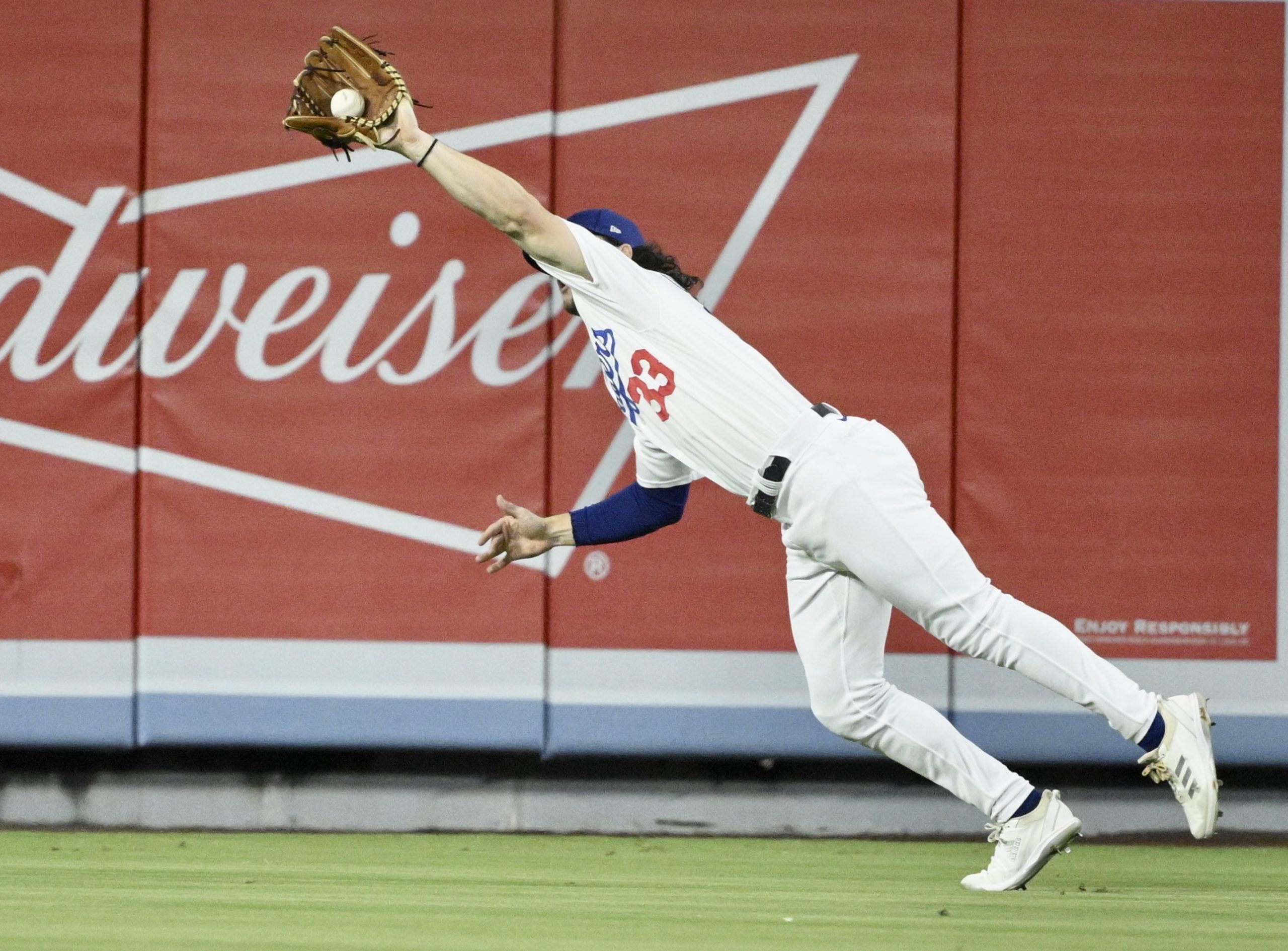 Dodgers center fielder James Outman makes a diving catch on...