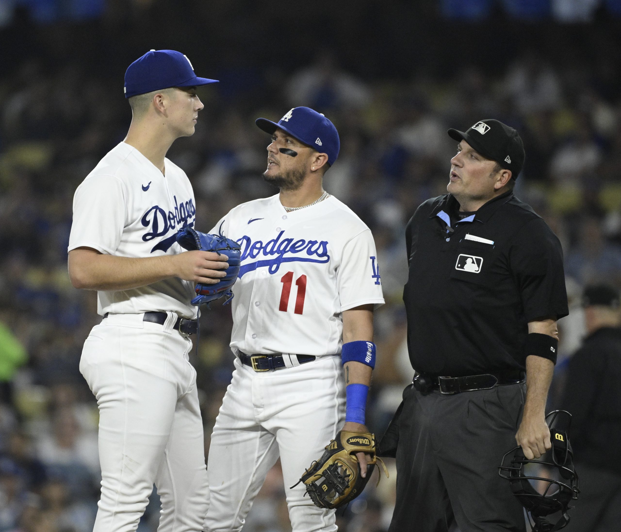 Dodgers shortstop Miguel Rojas, center, talks with starting pitcher Bobby...