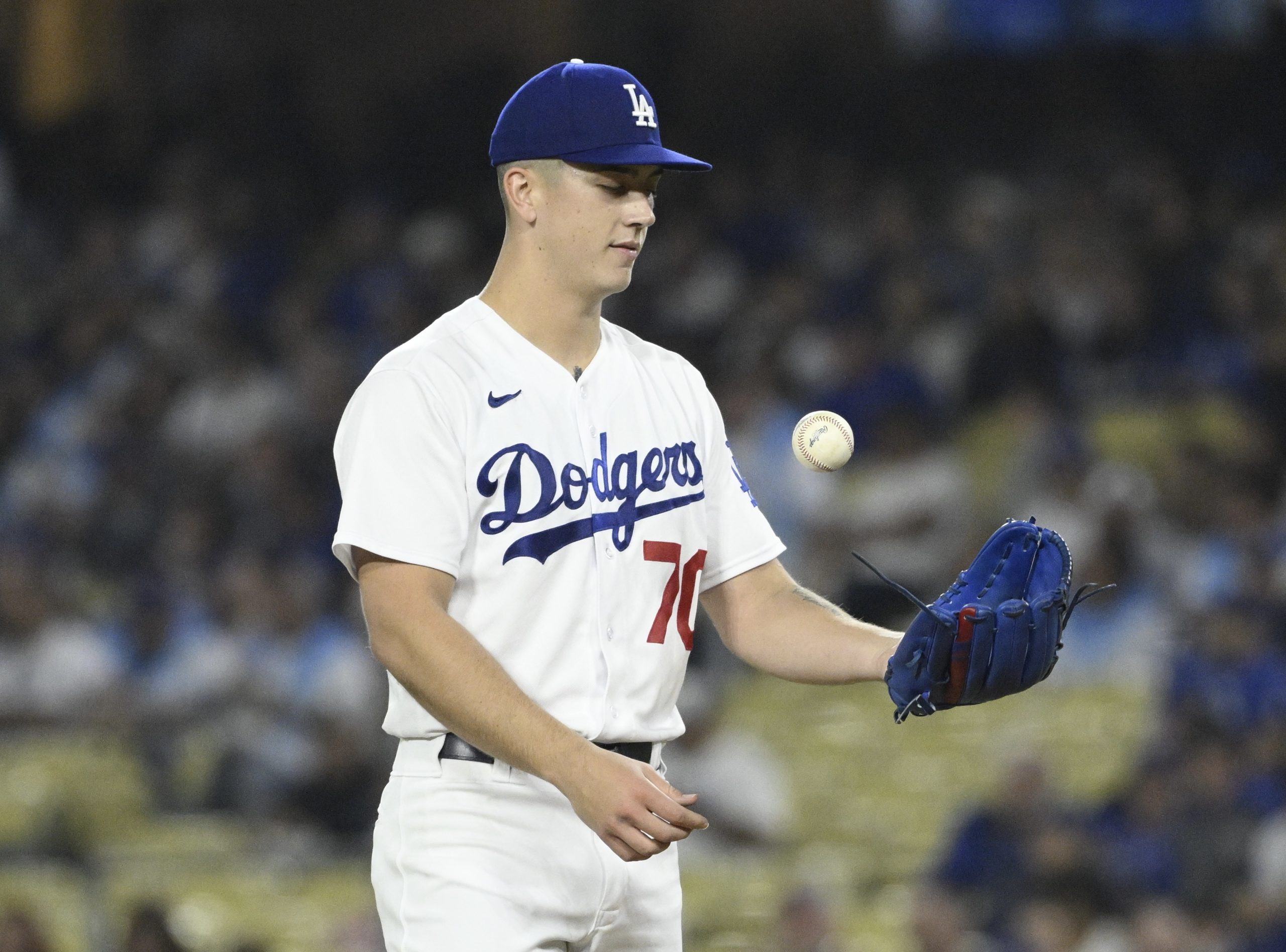Dodgers starting pitcher Bobby Miller flips a baseball after giving...