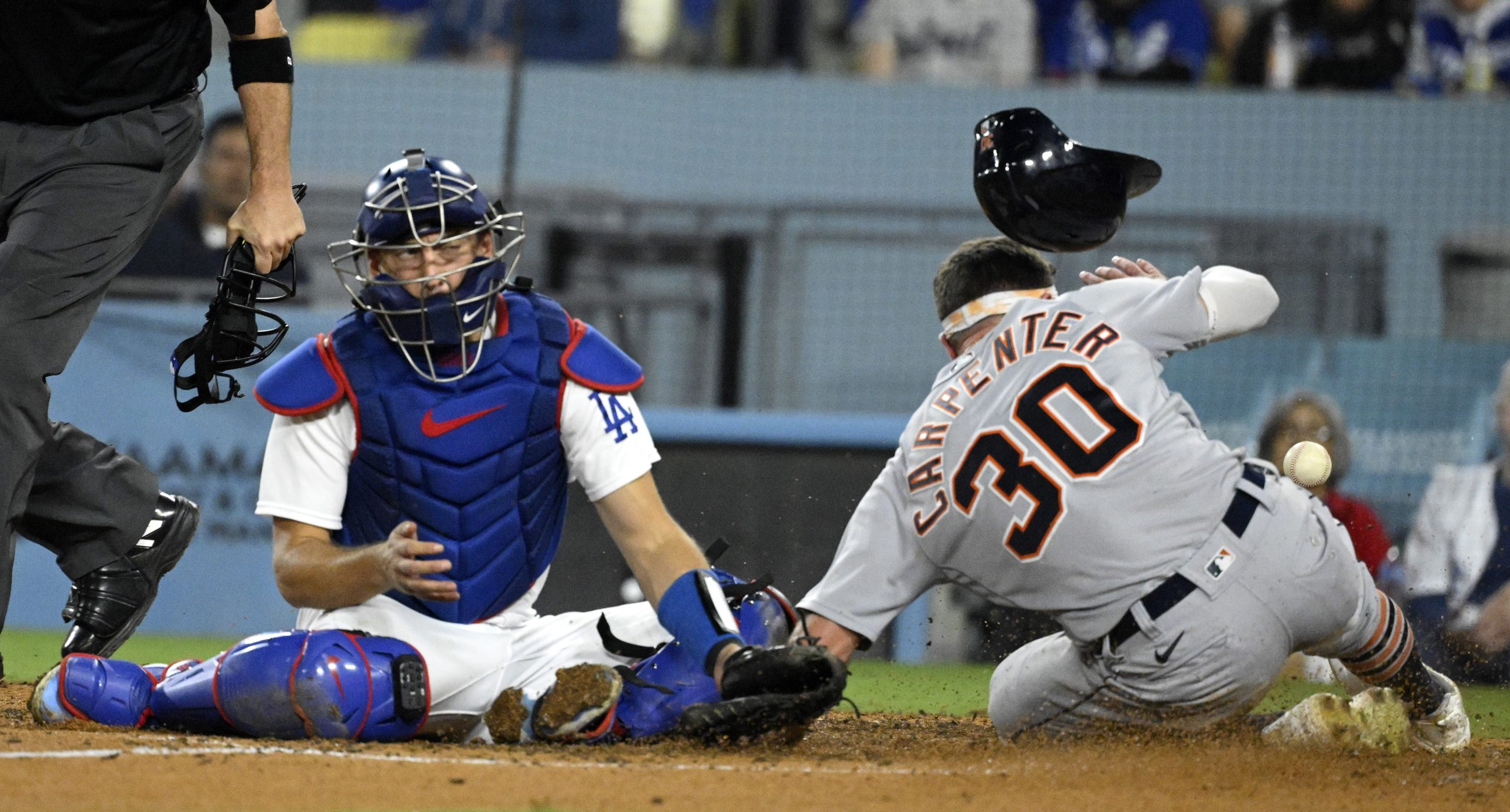 The Detroit Tigers’ Kerry Carpenter slides home past Dodgers catcher...
