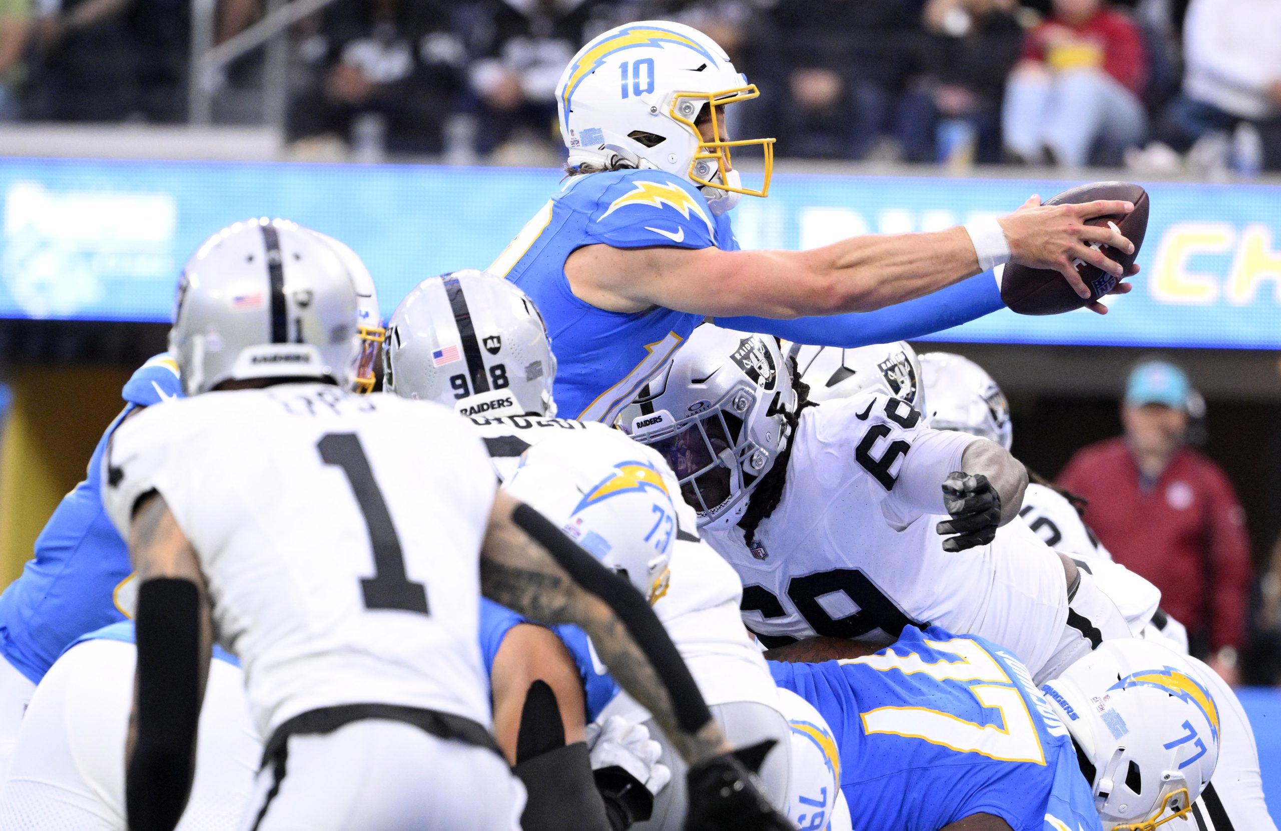 Quarterback Justin Herbert #10 of the Los Angeles Chargers reaches...