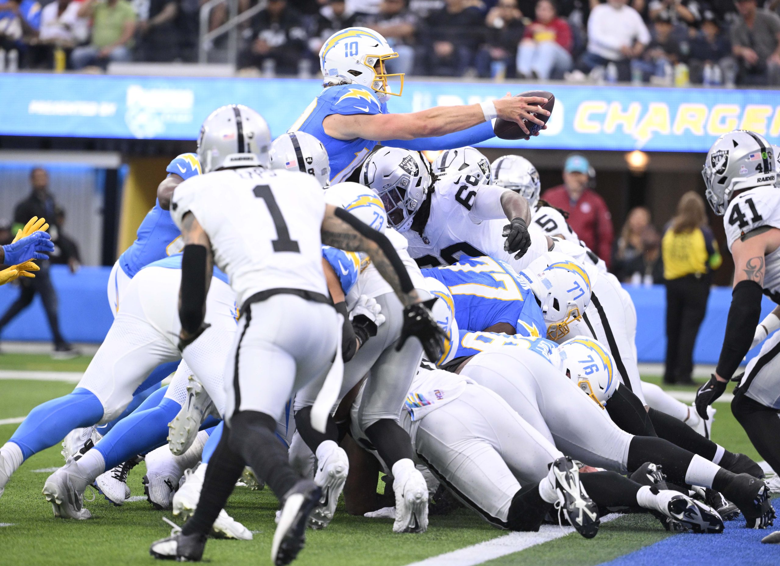 Quarterback Justin Herbert #10 of the Los Angeles Chargers reaches...