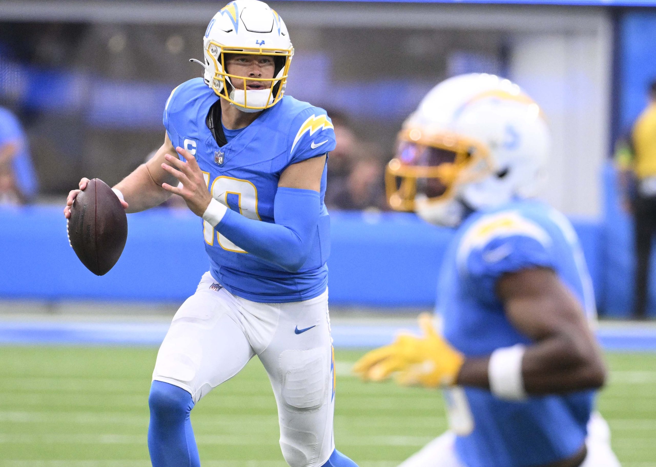 Quarterback Justin Herbert #10 of the Los Angeles Chargers scrambles...
