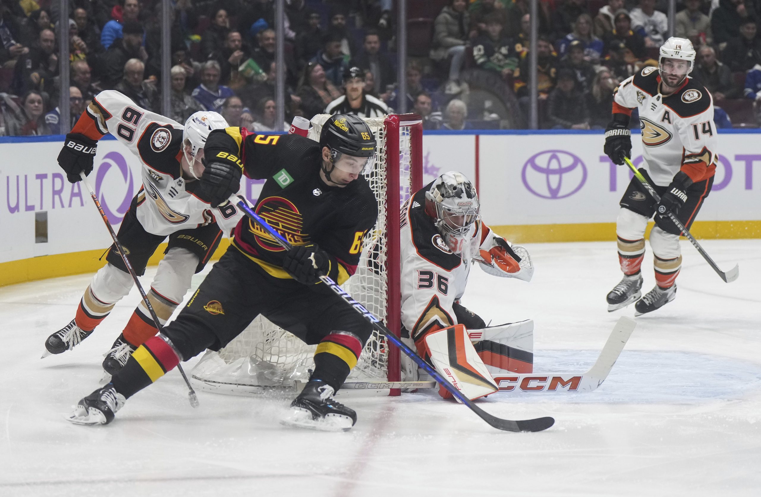 The Vancouver Canucks’ Ilya Mikheyev (65) is stopped by Ducks...