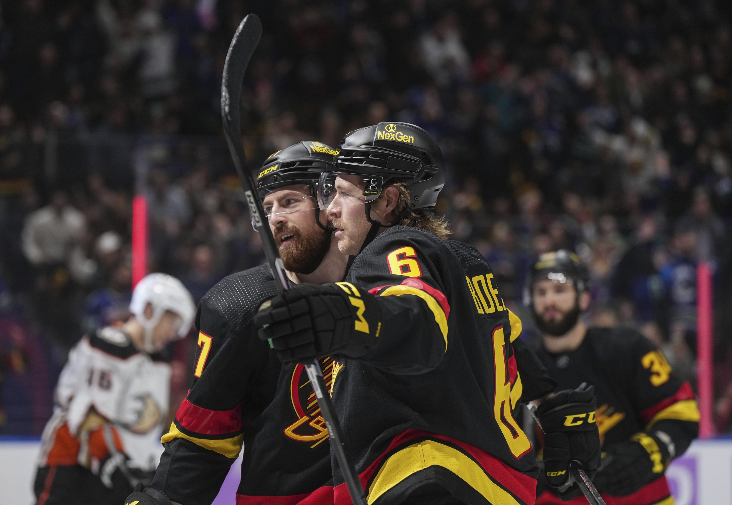 The Vancouver Canucks’ Brock Boeser, front right, and Filip Hronek...