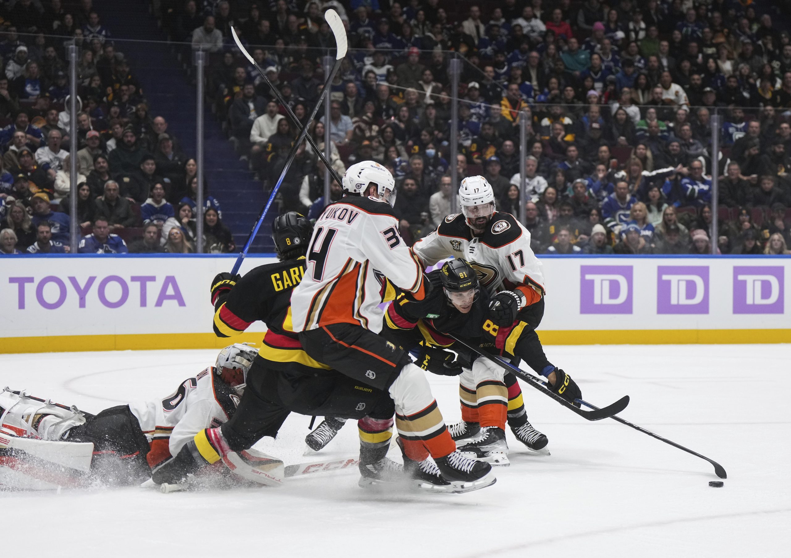 The Ducks’ Alex Killorn, far right, checks the Vancouver Canucks’...