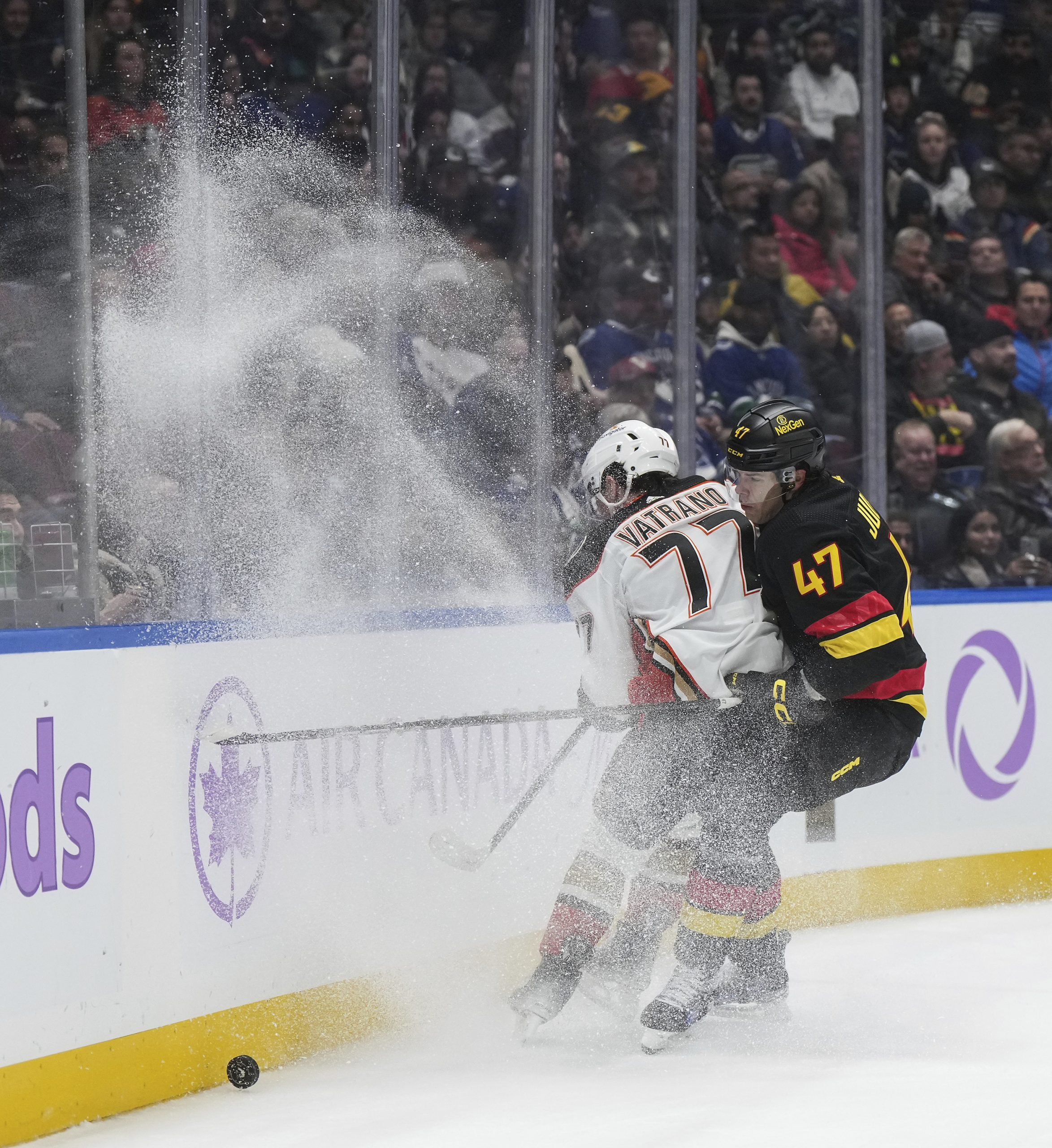 The Vancouver Canucks’ Noah Juulsen, right, checks the Ducks’ Frank...