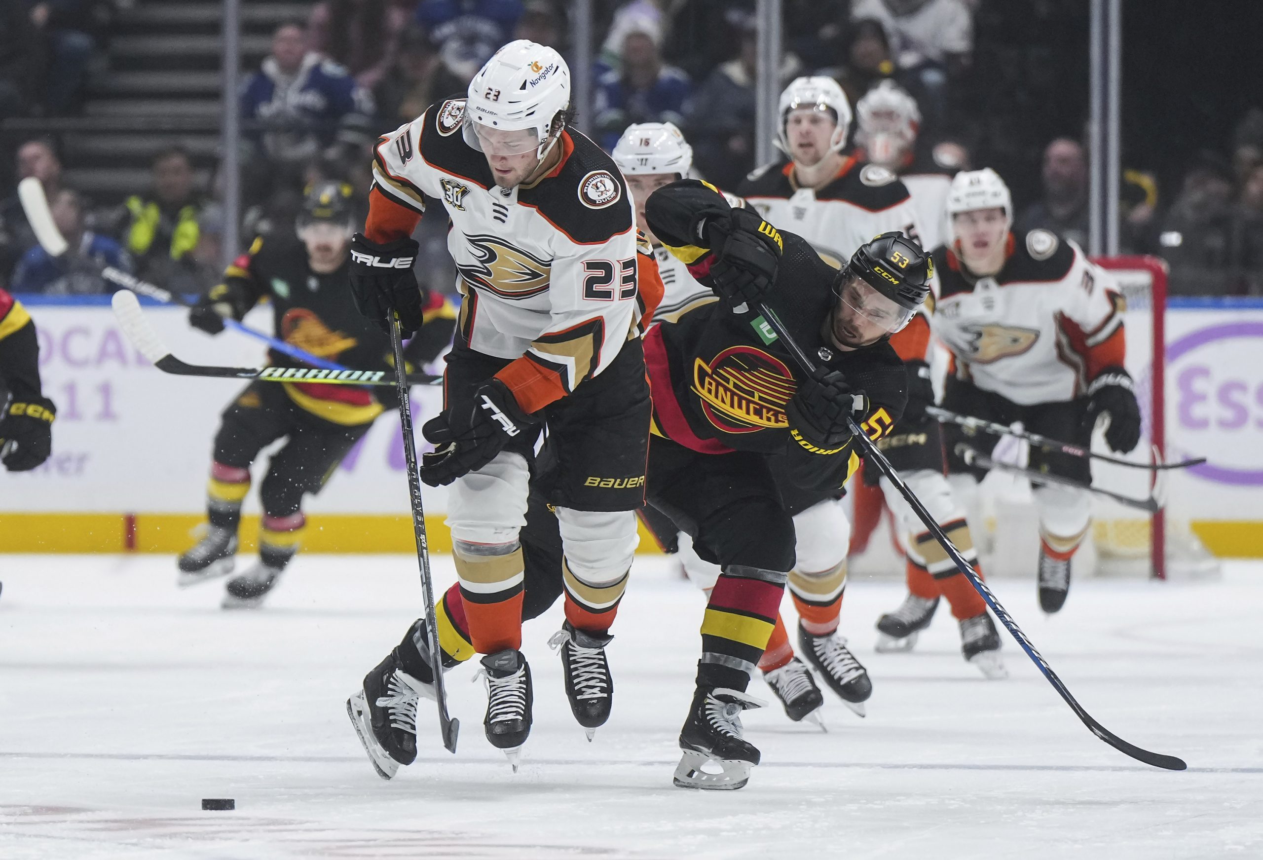 The Ducks’ Mason McTavish, left, and the Vancouver Canucks’ Teddy...