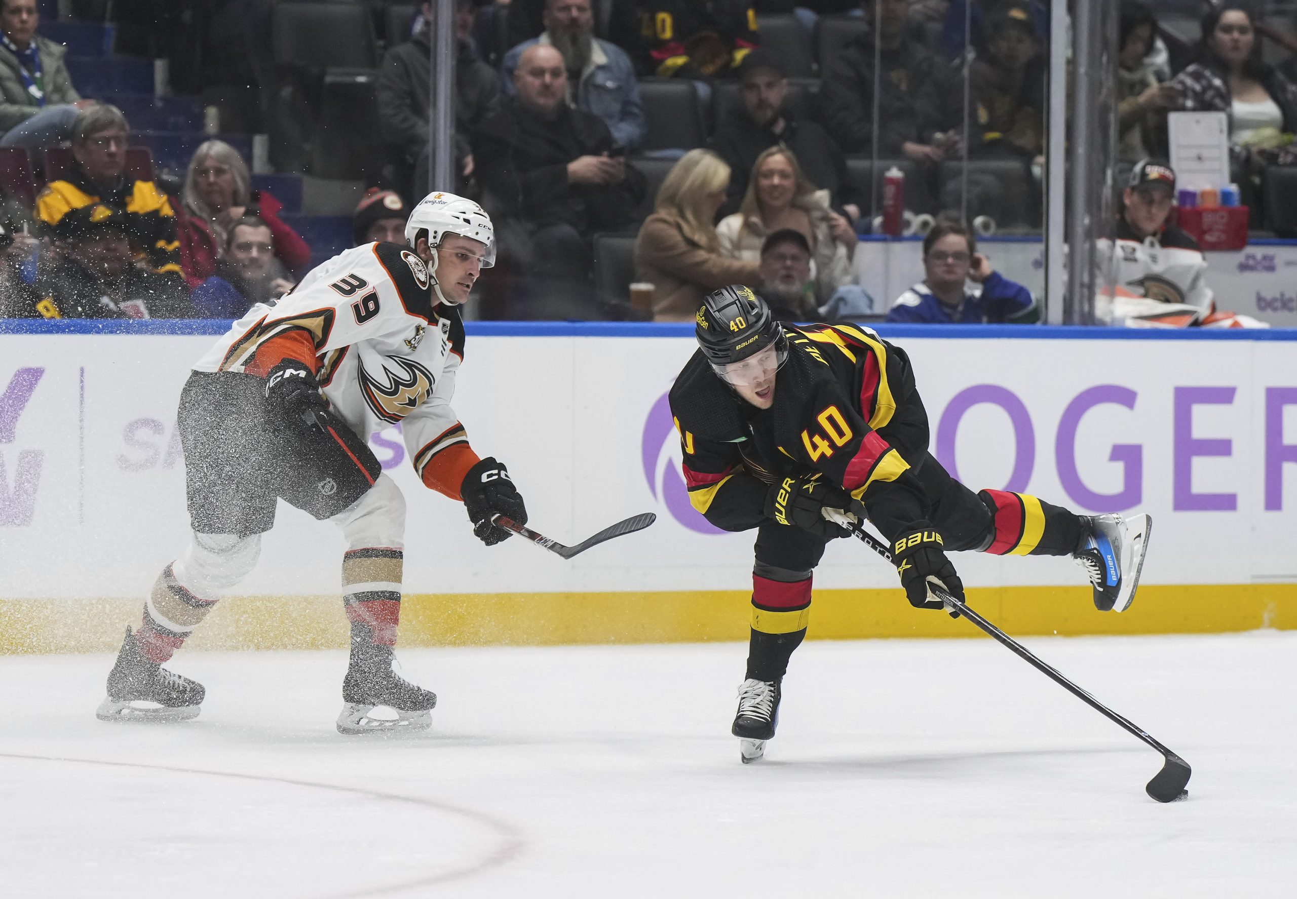 The Vancouver Canucks’ Elias Pettersson, right, reaches for the puck...