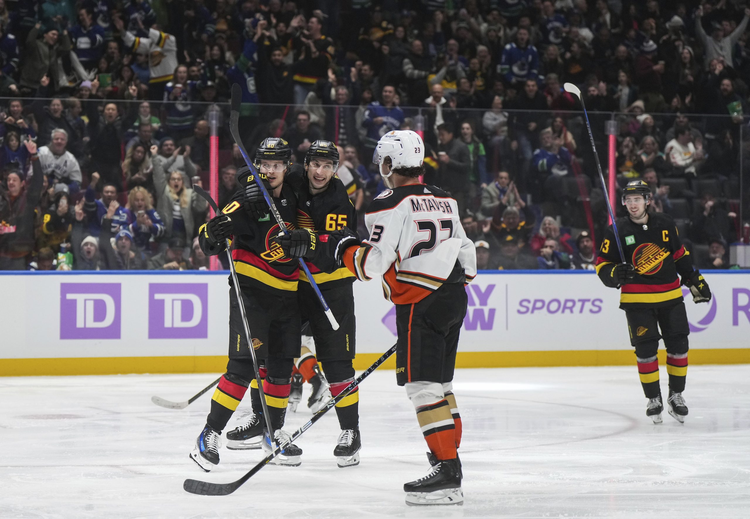 The Vancouver Canucks’ Elias Pettersson, back left, and Ilya Mikheyev...
