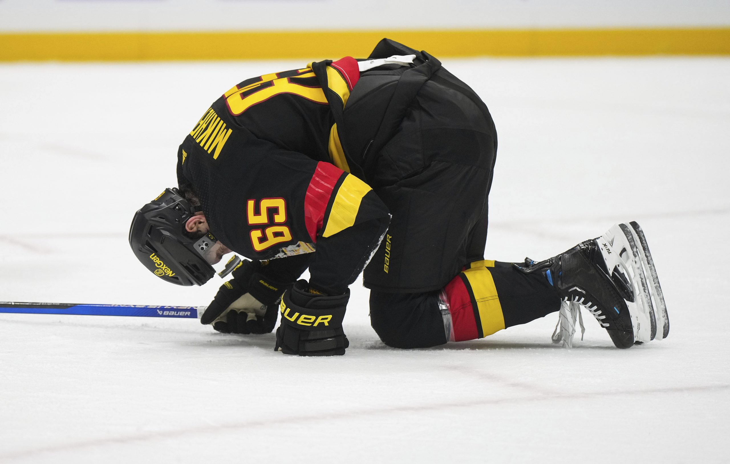 The Vancouver Canucks’ Ilya Mikheyev kneels on the ice after...