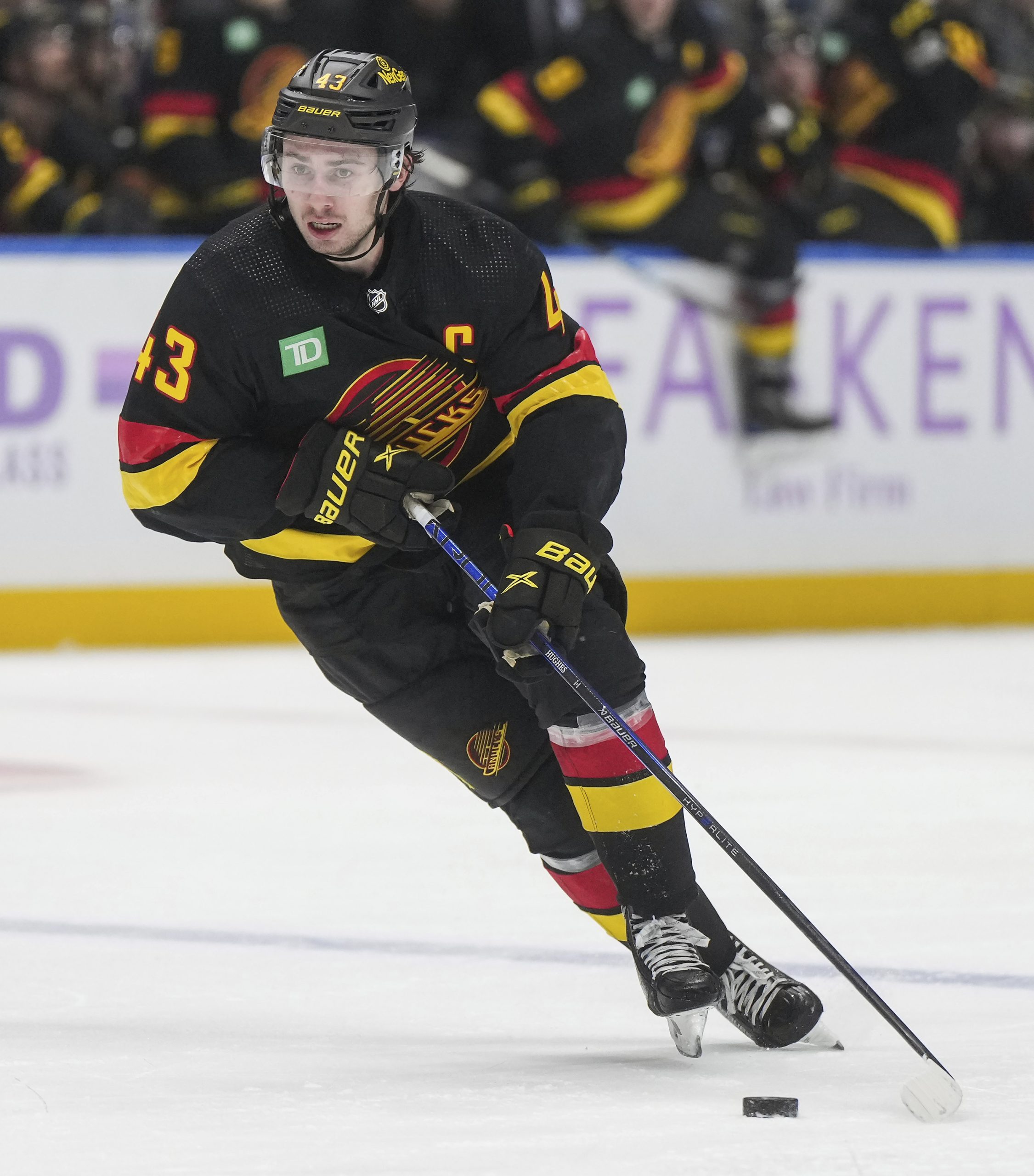 The Vancouver Canucks’ Quinn Hughes skates with the puck during...