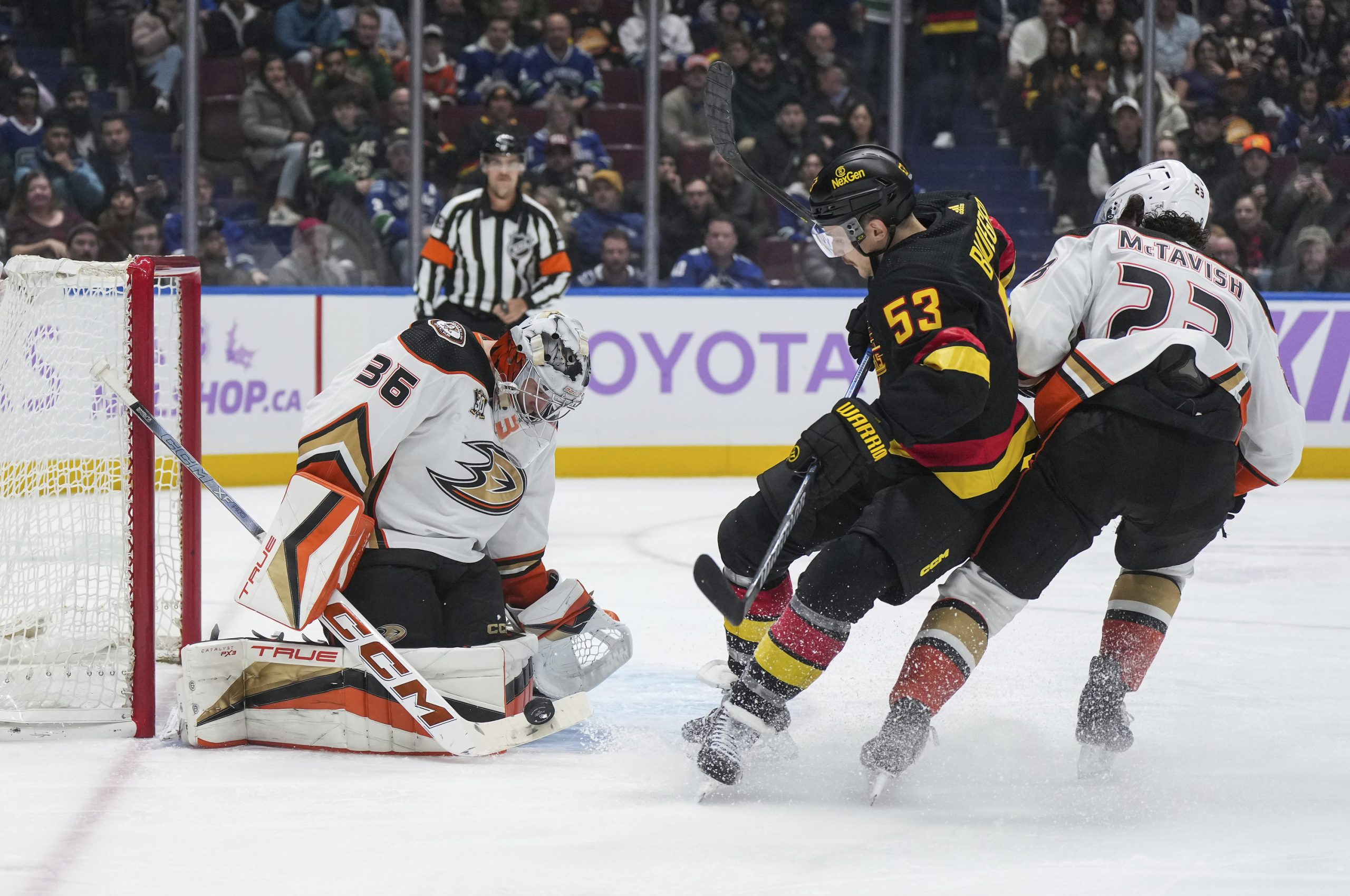 Ducks goalie John Gibson, left, stops a shot by the...