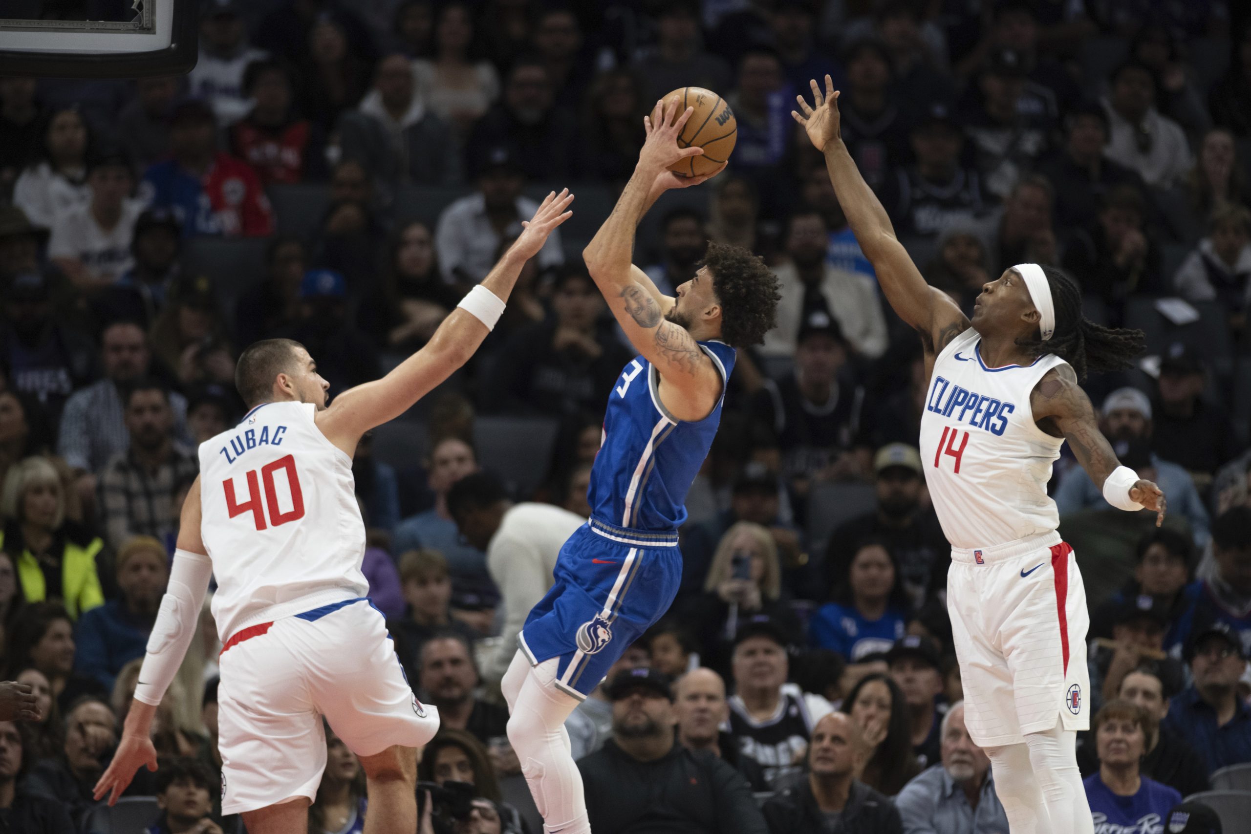 Sacramento Kings guard Chris Duarte shoots between Clippers center Ivica...