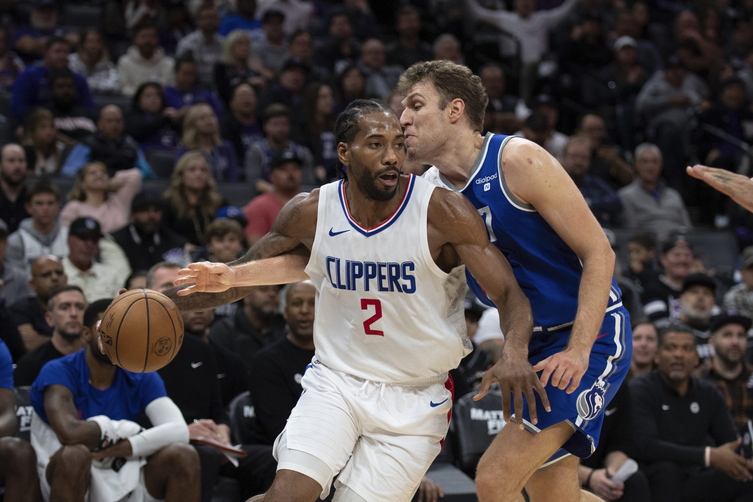 Clippers forward Kawhi Leonard, left, handles the ball as Sacramento...