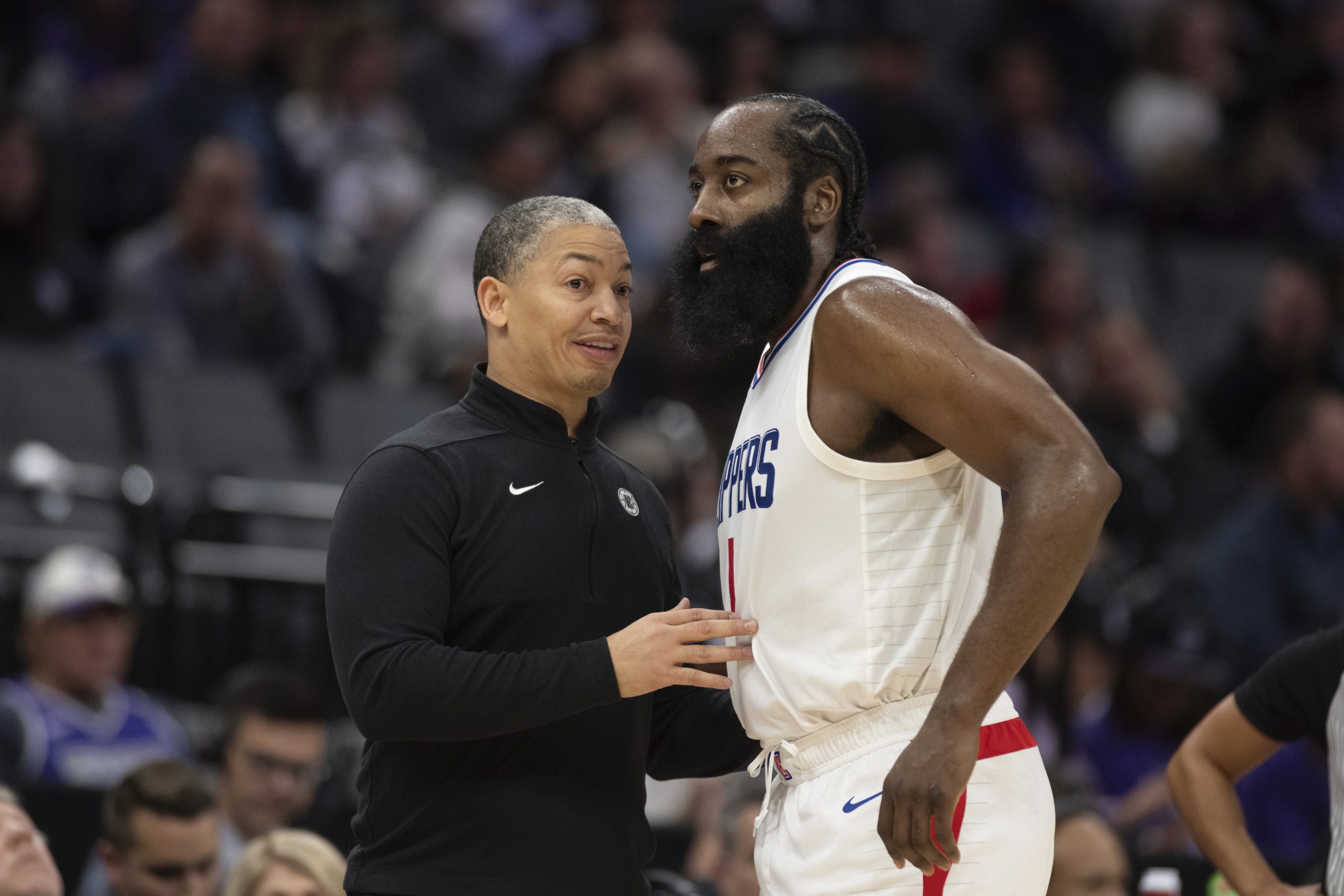 Clippers coach Tyrone Lue, left, talks with guard James Harden...