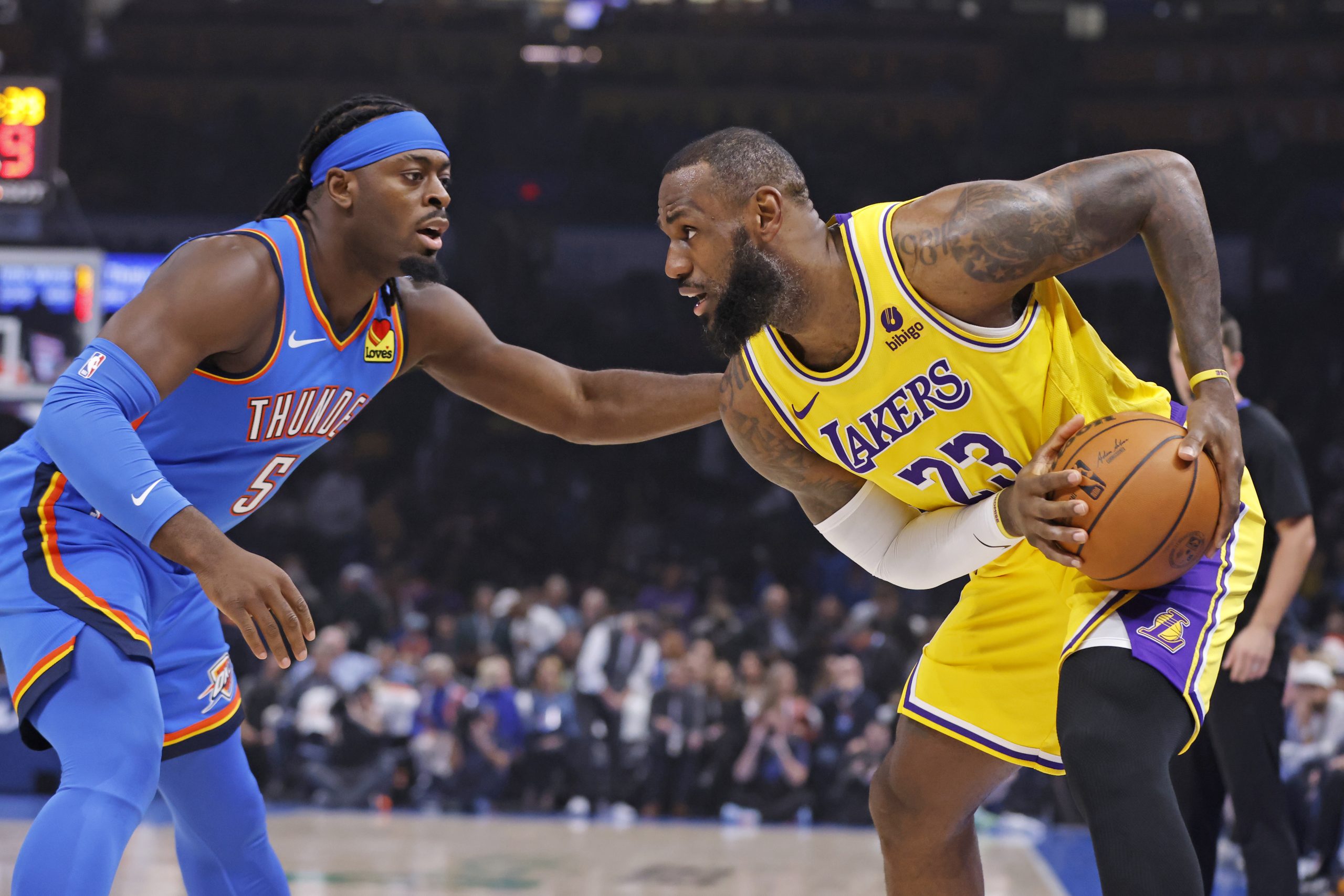 Lakers forward LeBron James, right, holds the ball as Oklahoma...