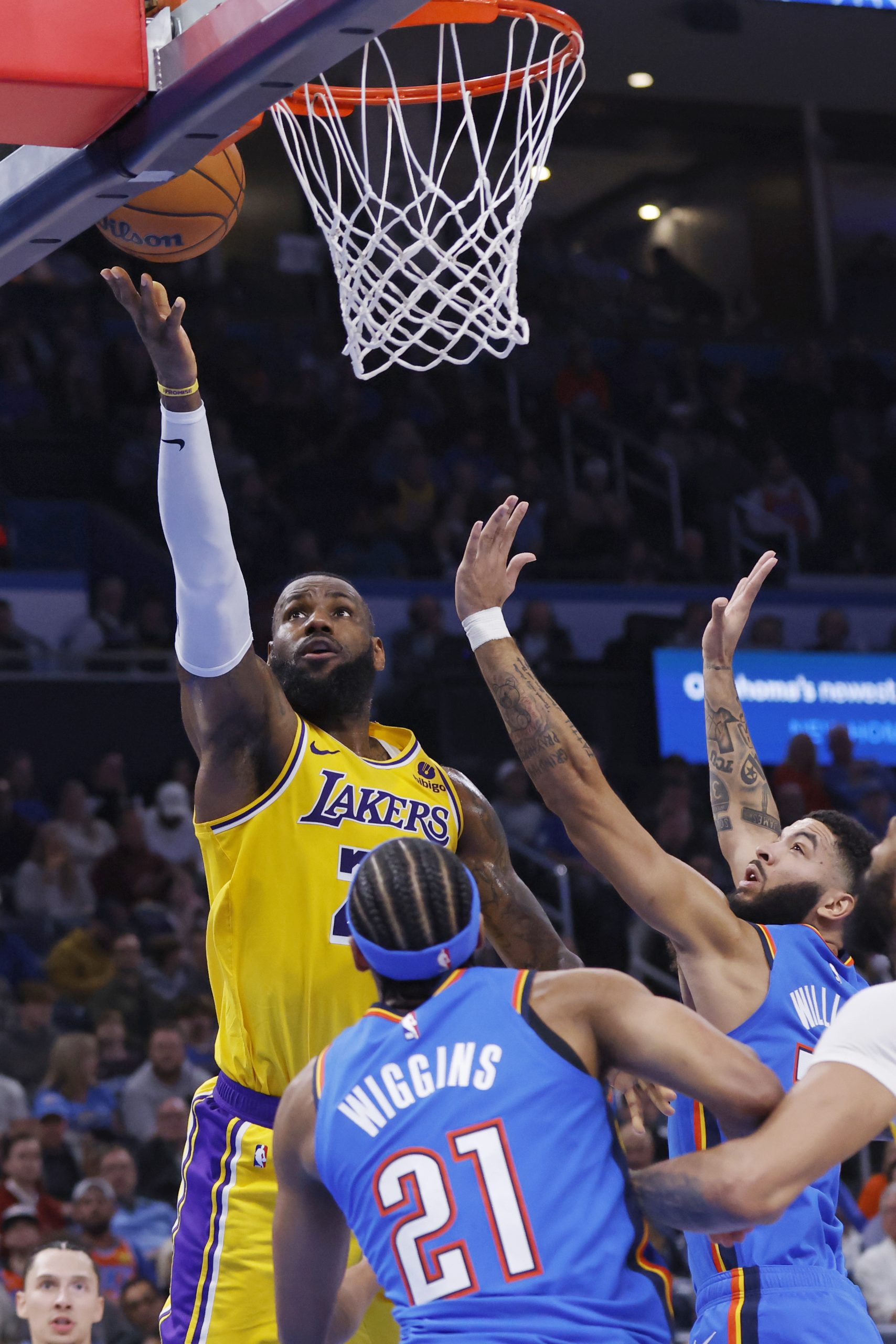 Lakers forward LeBron James, left, shoots near Oklahoma City Thunder...