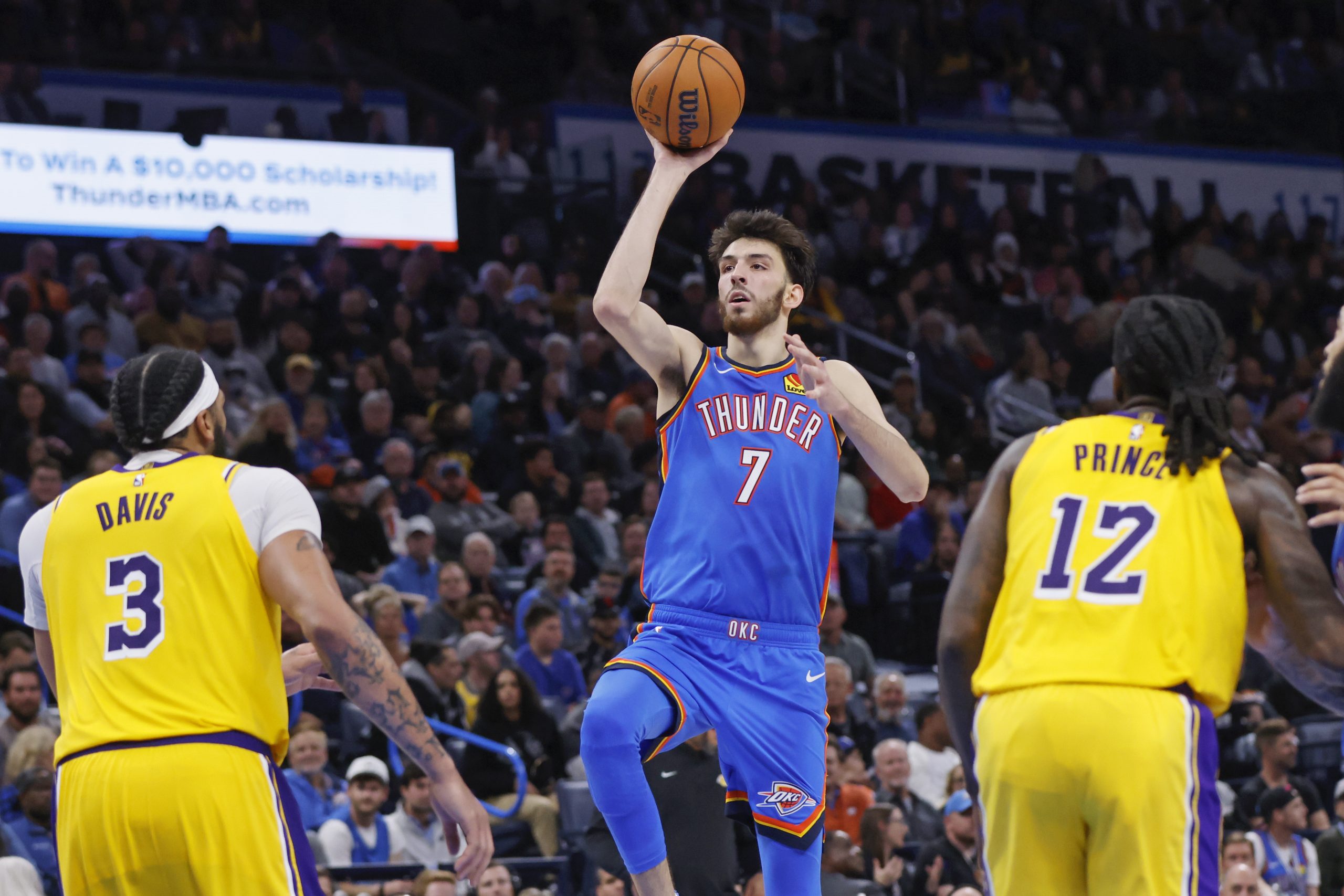 Oklahoma City Thunder forward Chet Holmgren shoots from between Lakers...