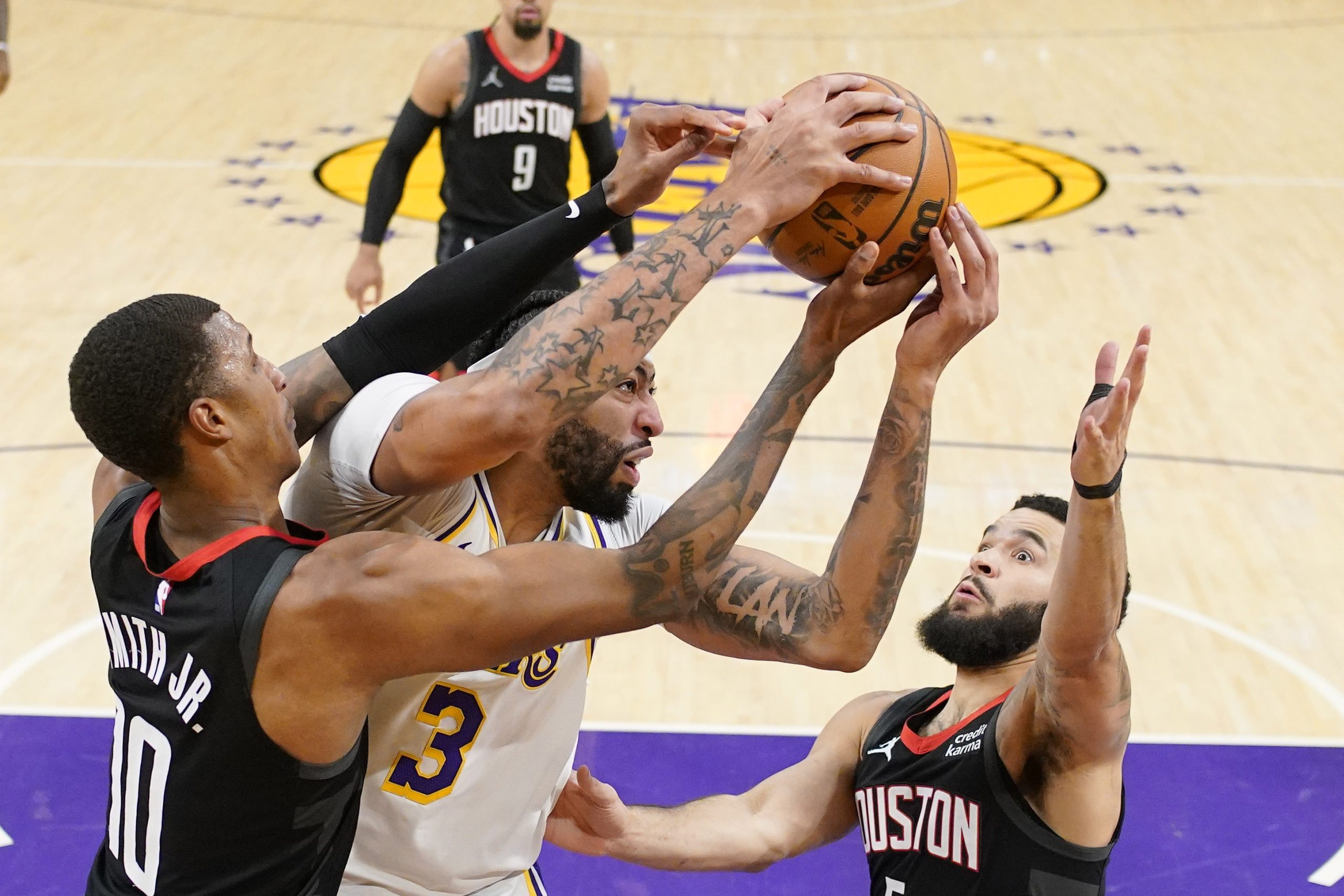 Los Angeles Lakers forward Anthony Davis, center, grabs rebound away...