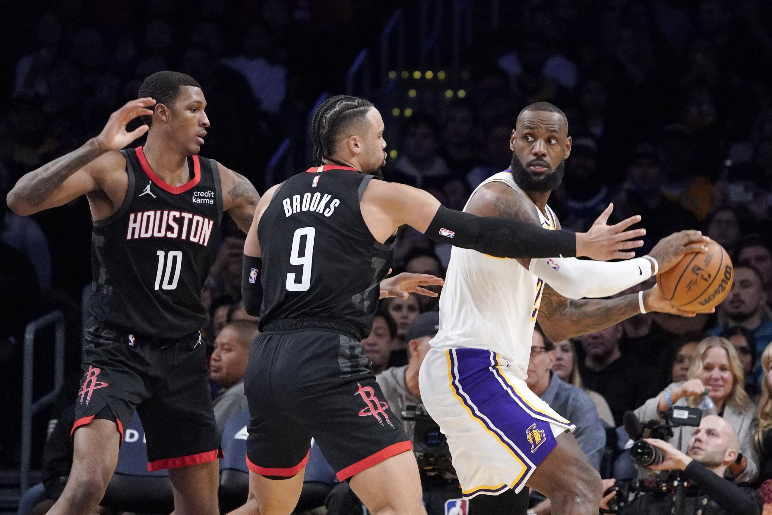 Los Angeles Lakers forward LeBron James, right, tries to pass...