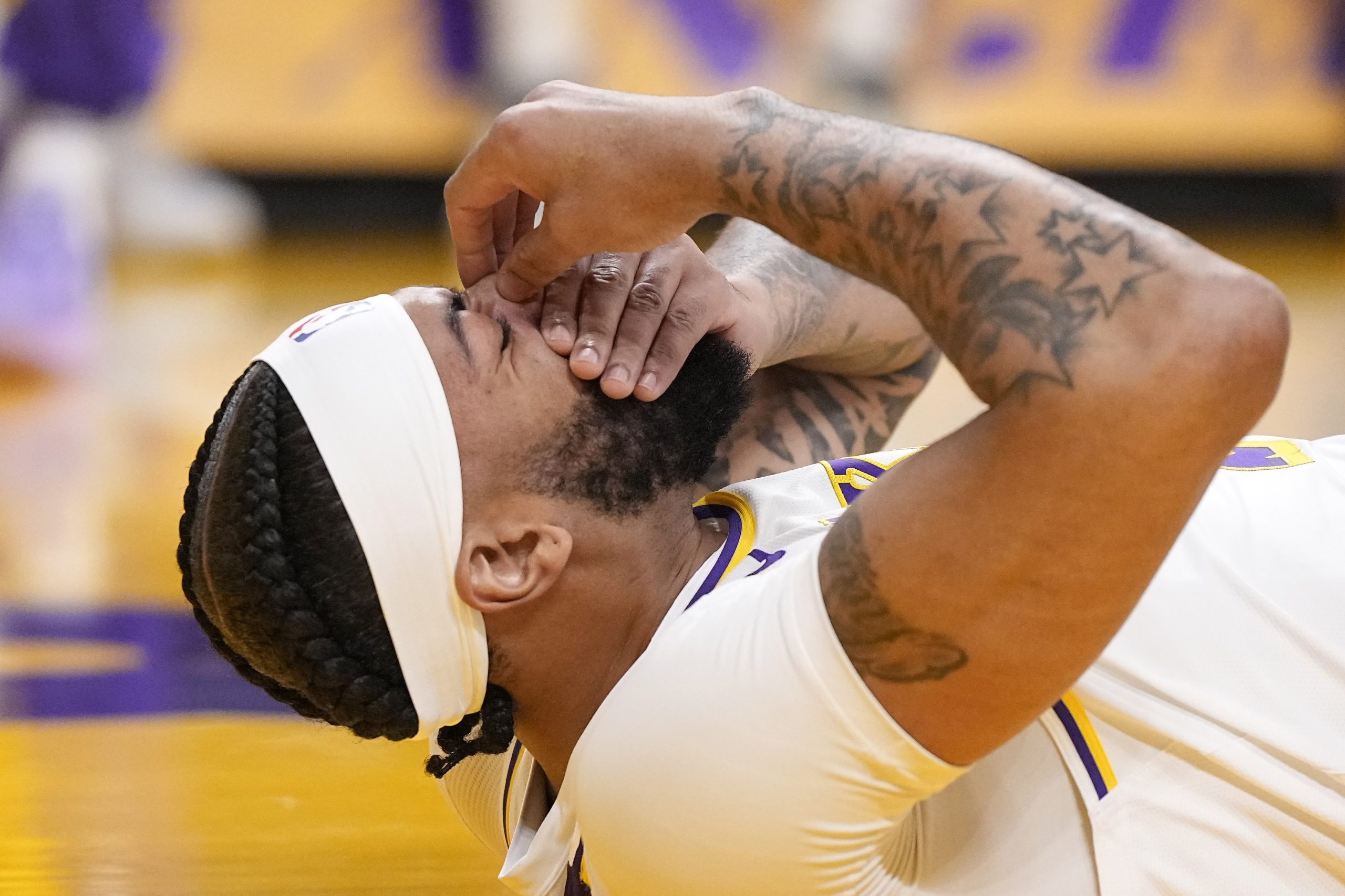 Los Angeles Lakers forward Anthony Davis holds his face after...