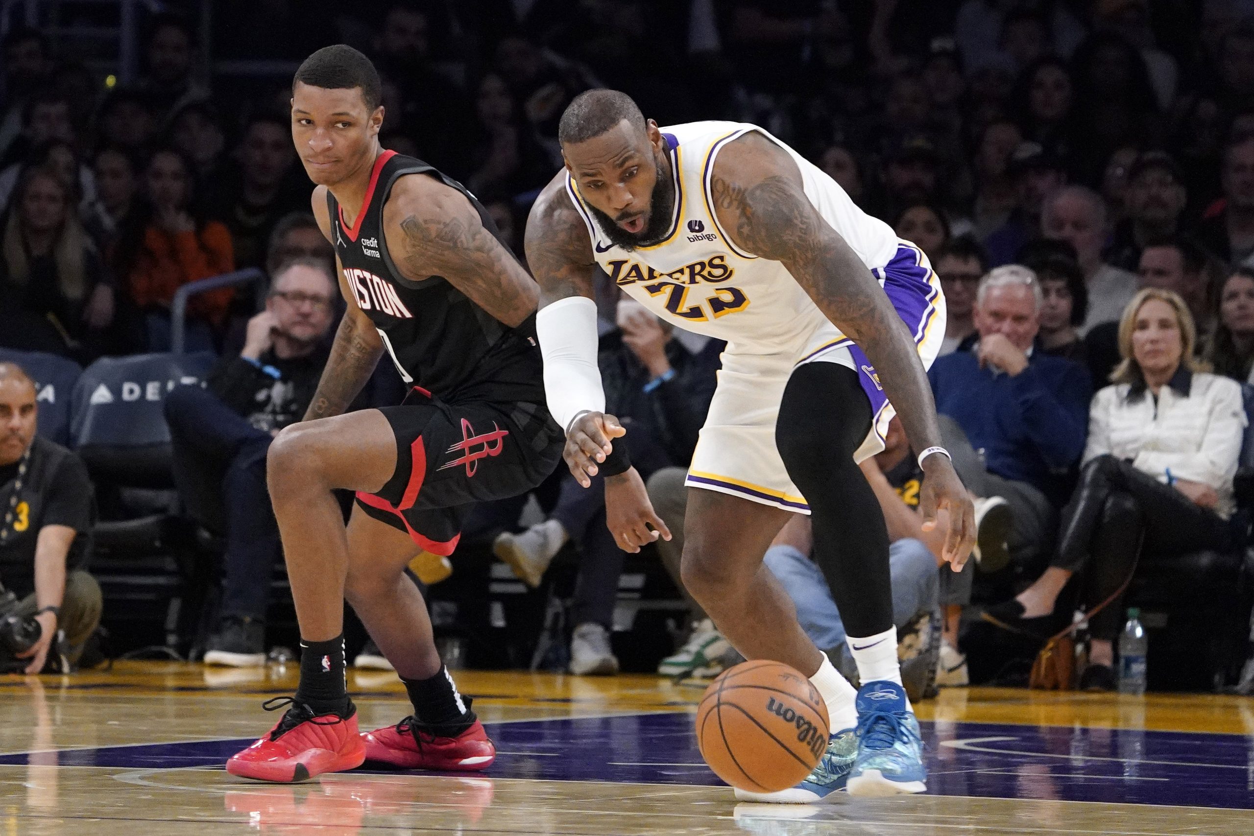 Los Angeles Lakers forward LeBron James, right, grabs a loose...