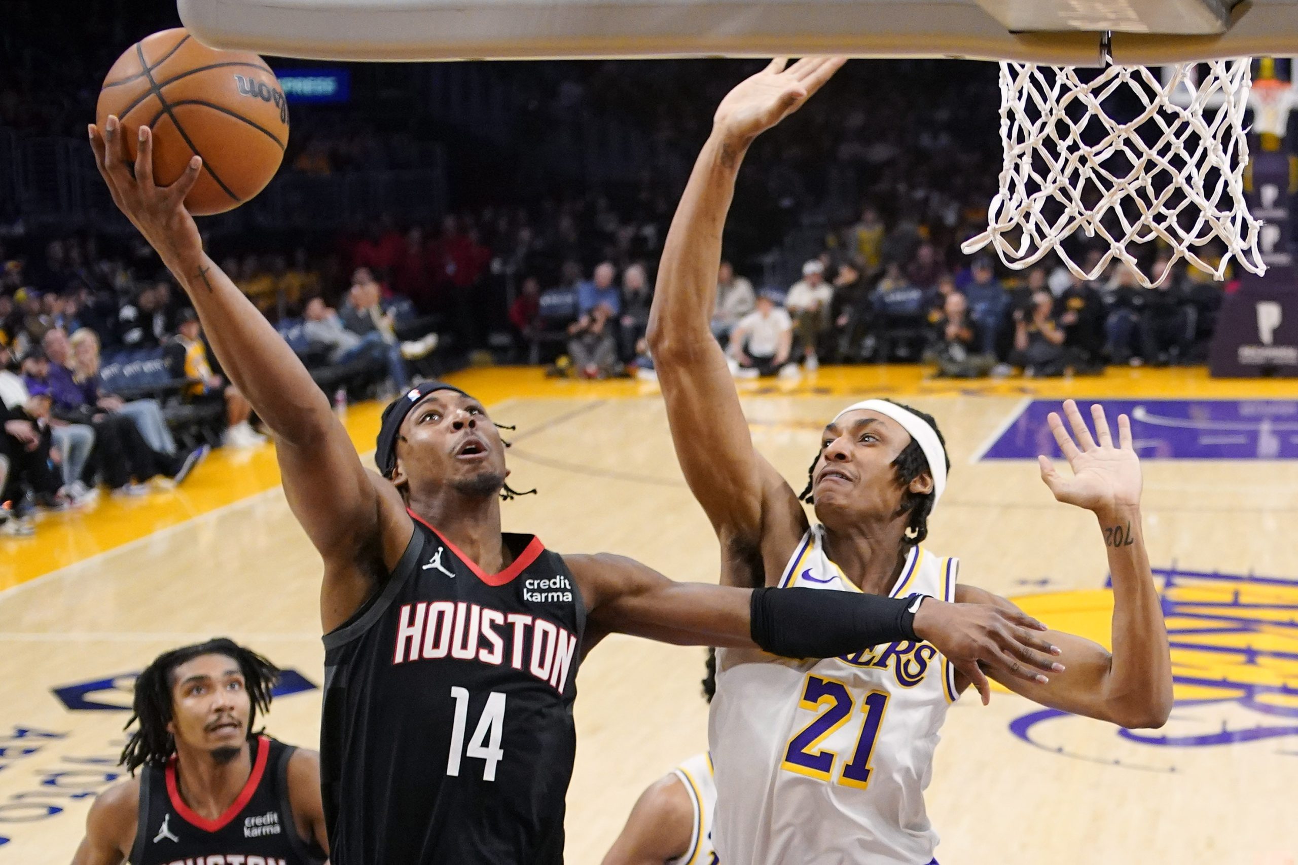 Houston Rockets guard Nate Hinton, center, shoots as Los Angeles...