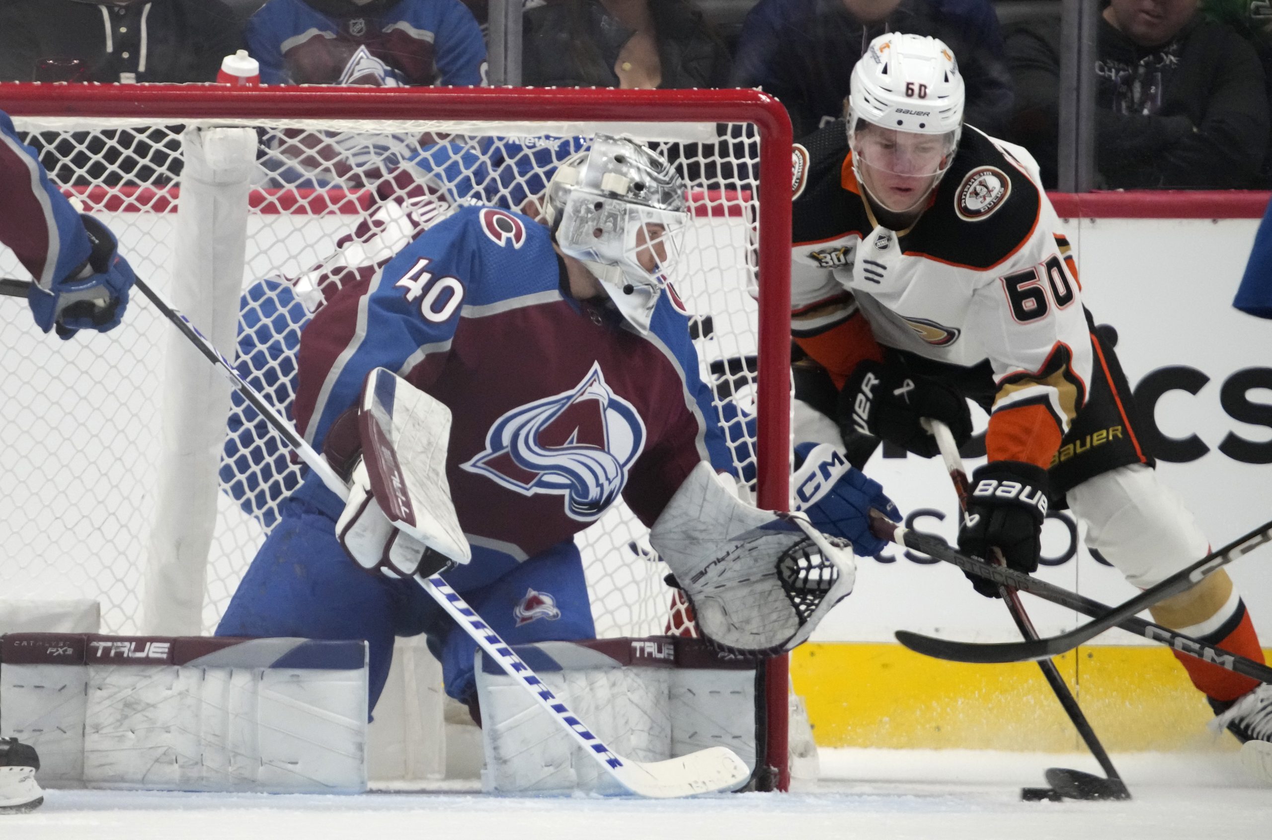 Ducks defenseman Jackson LaCombe, right, looks to score as Colorado...