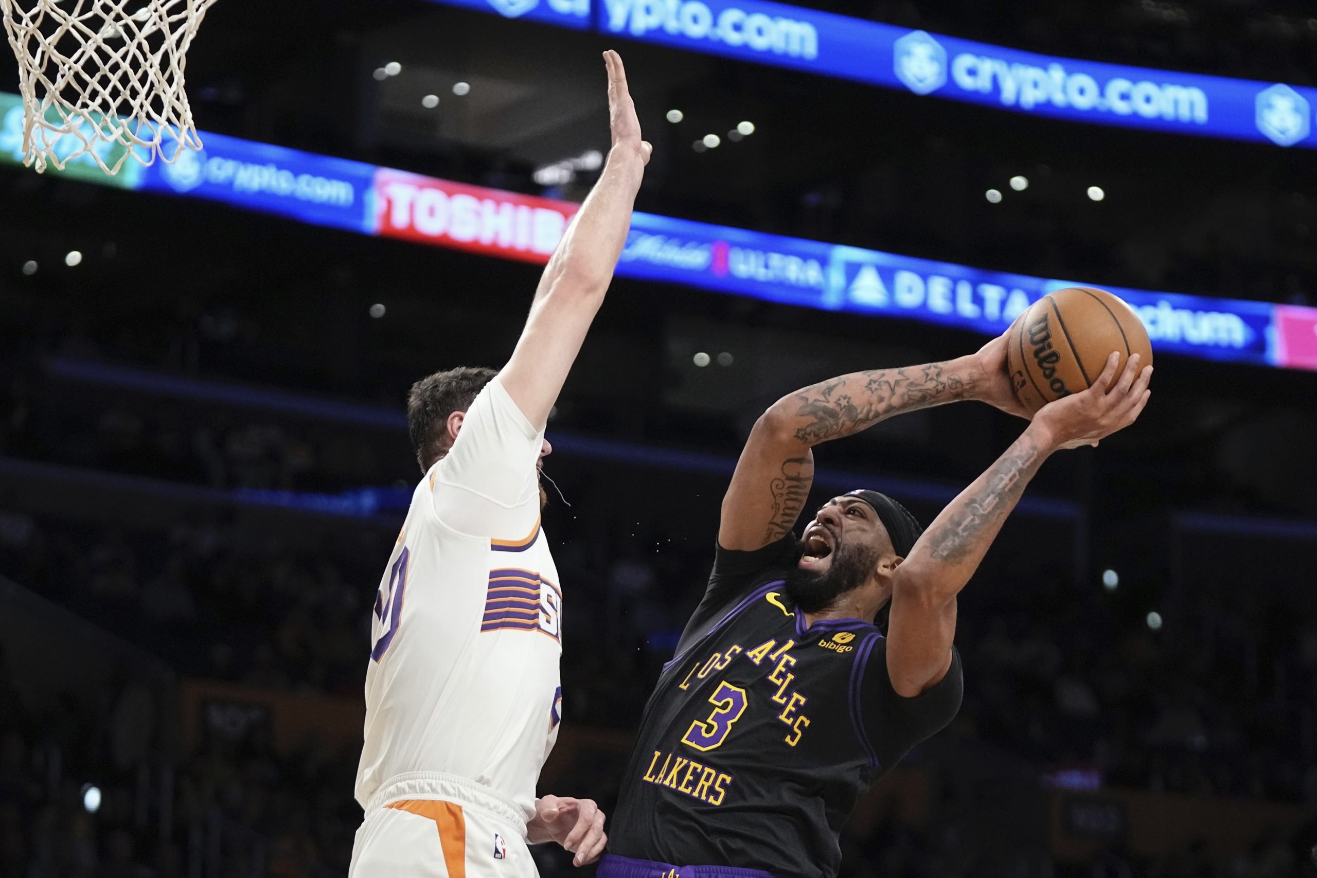 Lakers forward Anthony Davis, right shoots as Phoenix Suns center...