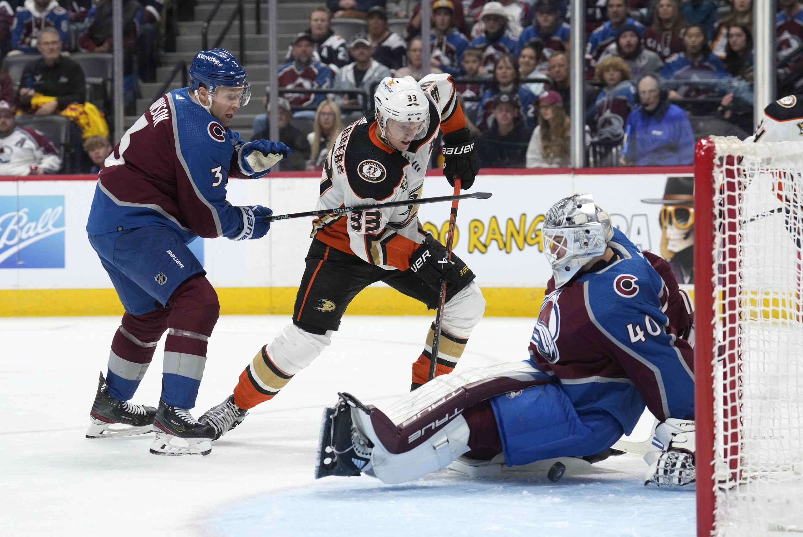 Colorado Avalanche goaltender Alexandar Georgiev, right, lands on the puck...