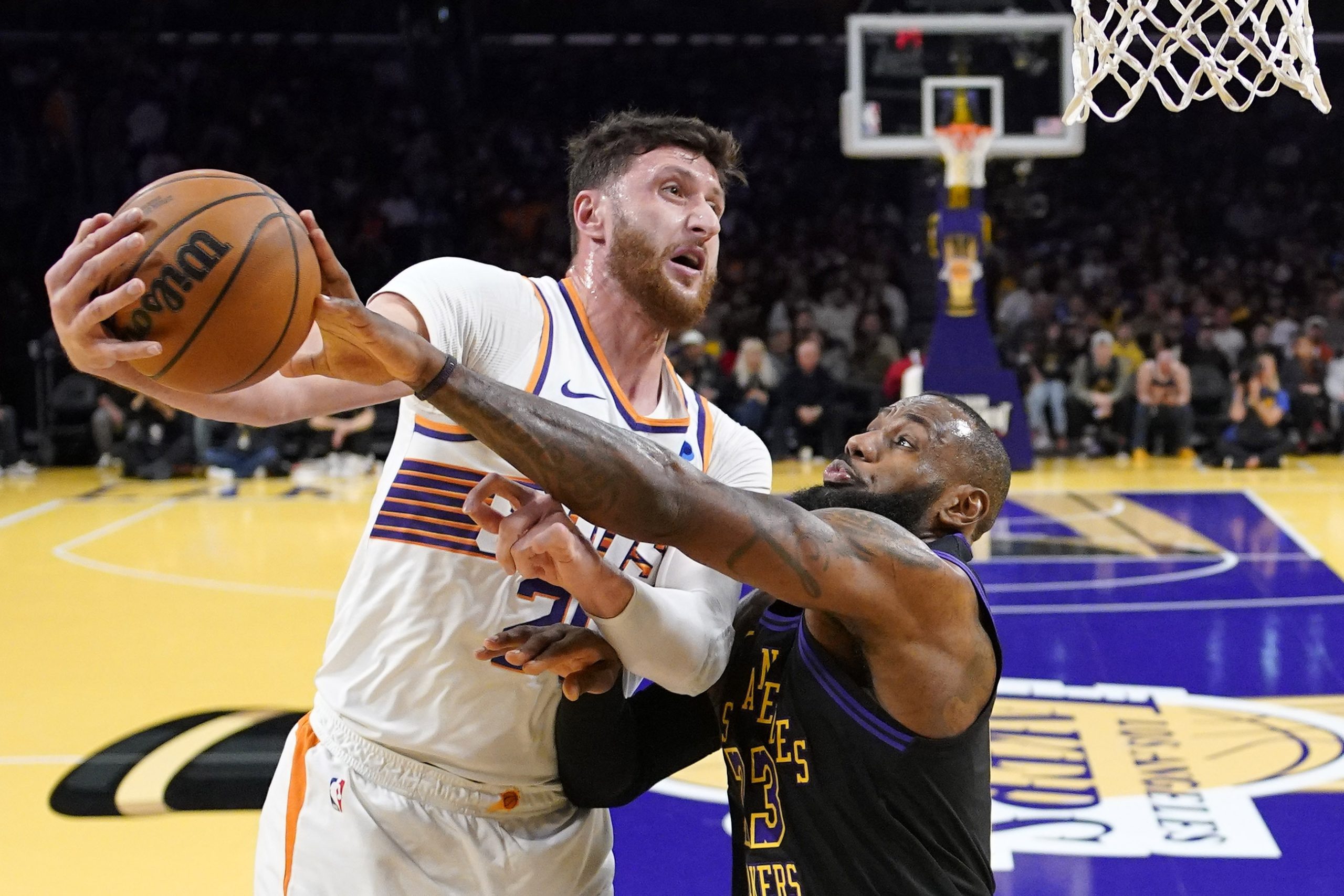 Phoenix Suns center Jusuf Nurkic, left, tries to shoot as...