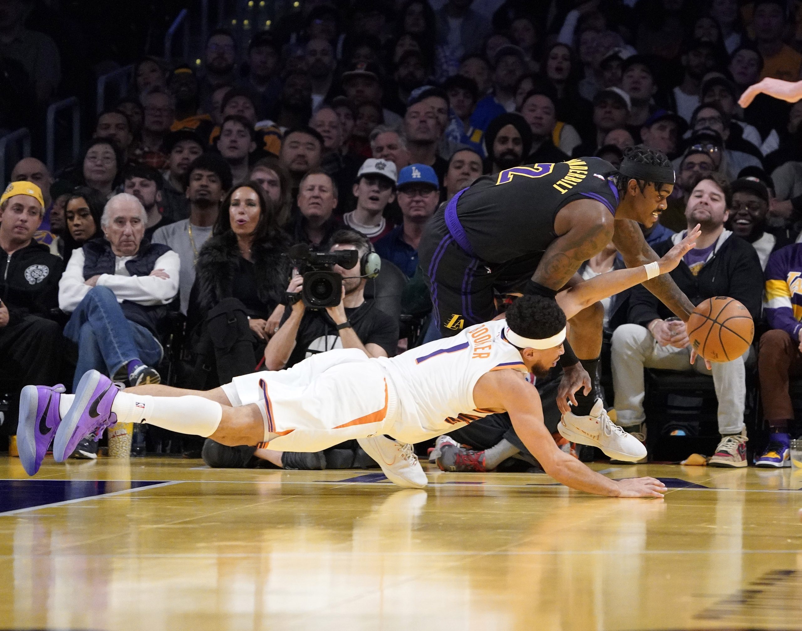Lakers forward Jarred Vanderbilt, right, scoops up a loose ball...