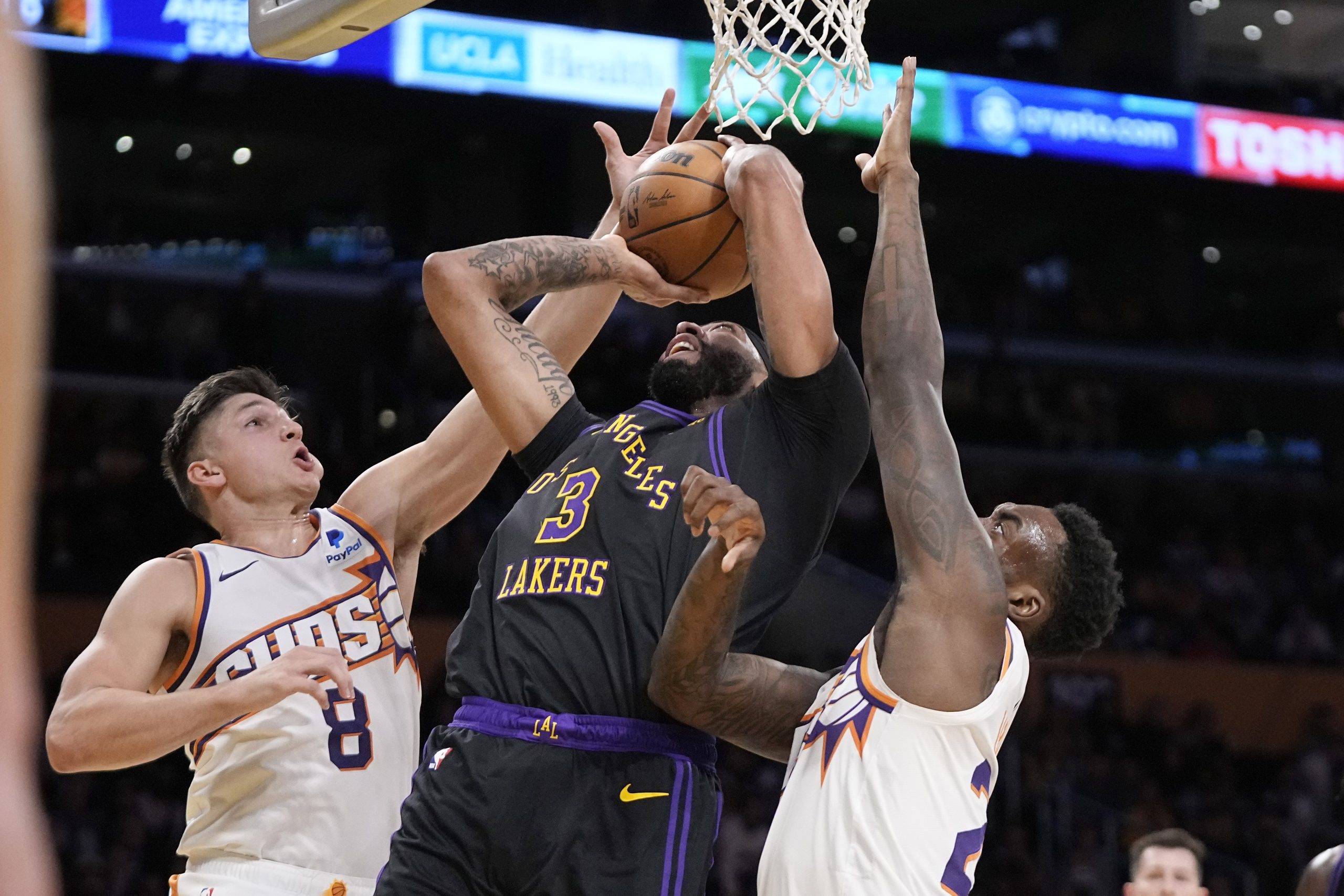 Lakers forward Anthony Davis, center, shoots as Phoenix Suns guard...