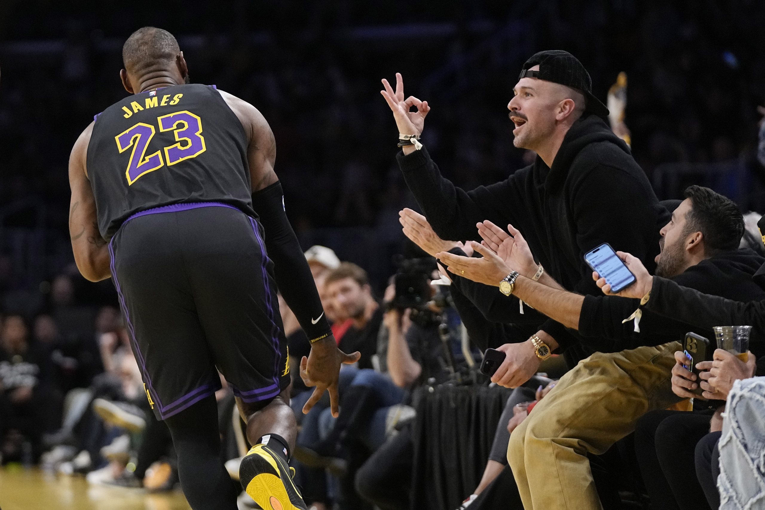 Fans celebrate after Lakers forward LeBron James hit a 3-point...