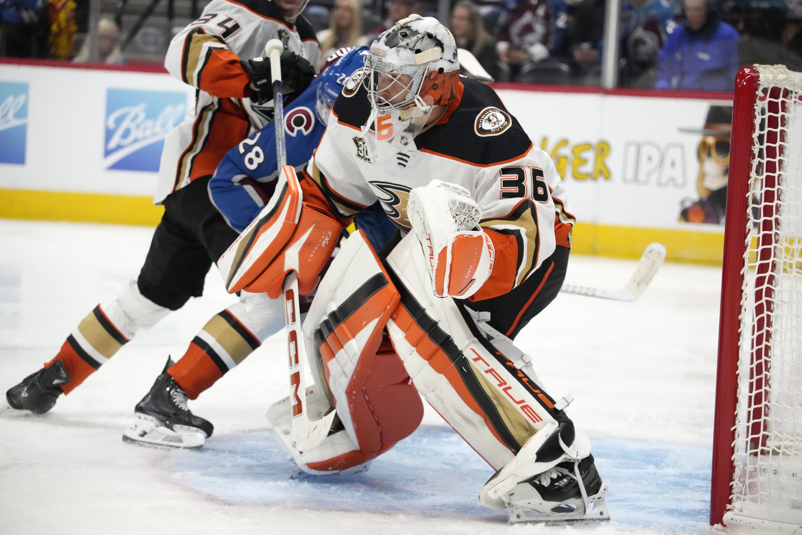 Ducks goaltender John Gibson, front, looks for the puck as...