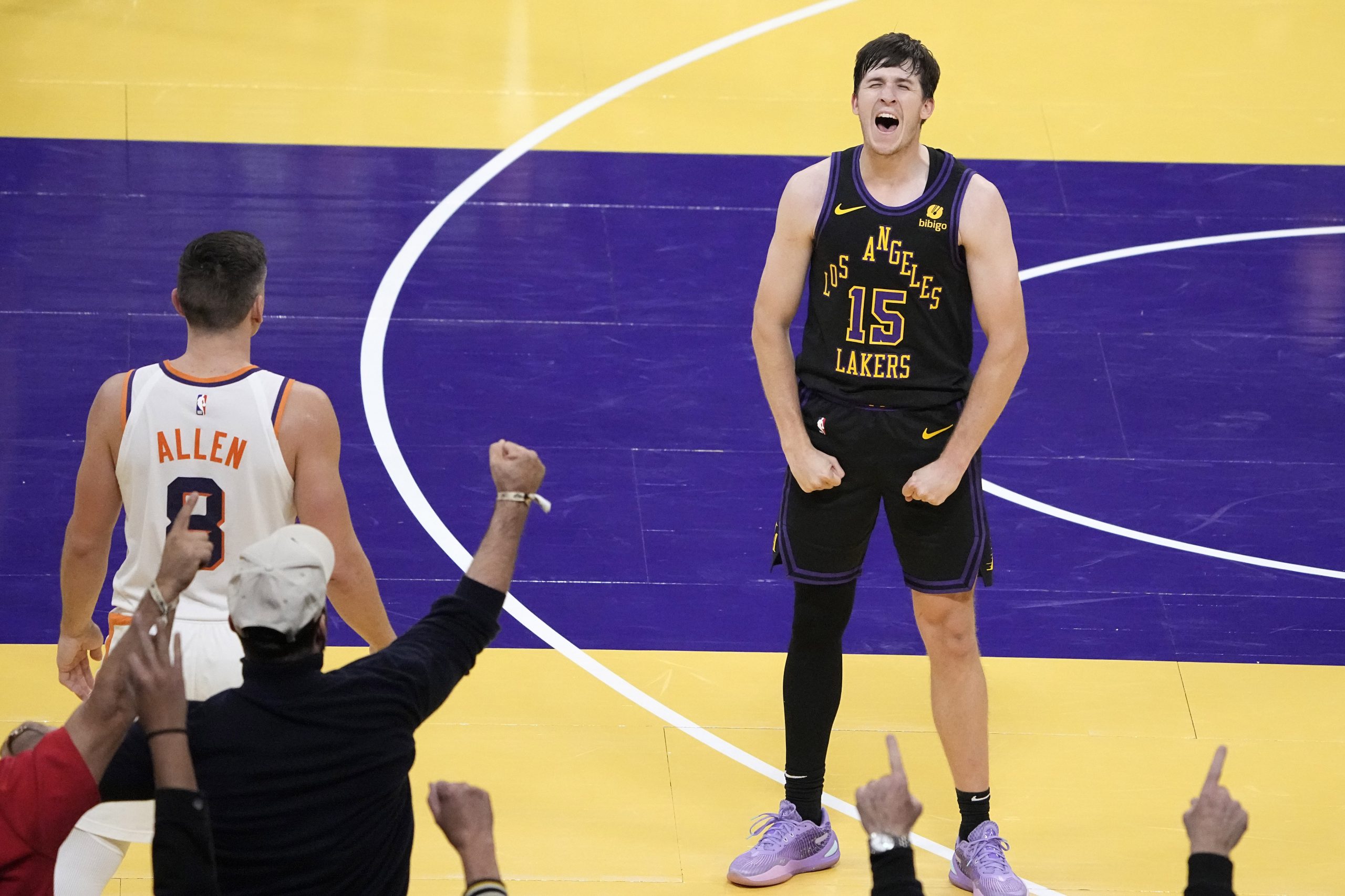 Lakers guard Austin Reaves, right, celebrates along with fans after...