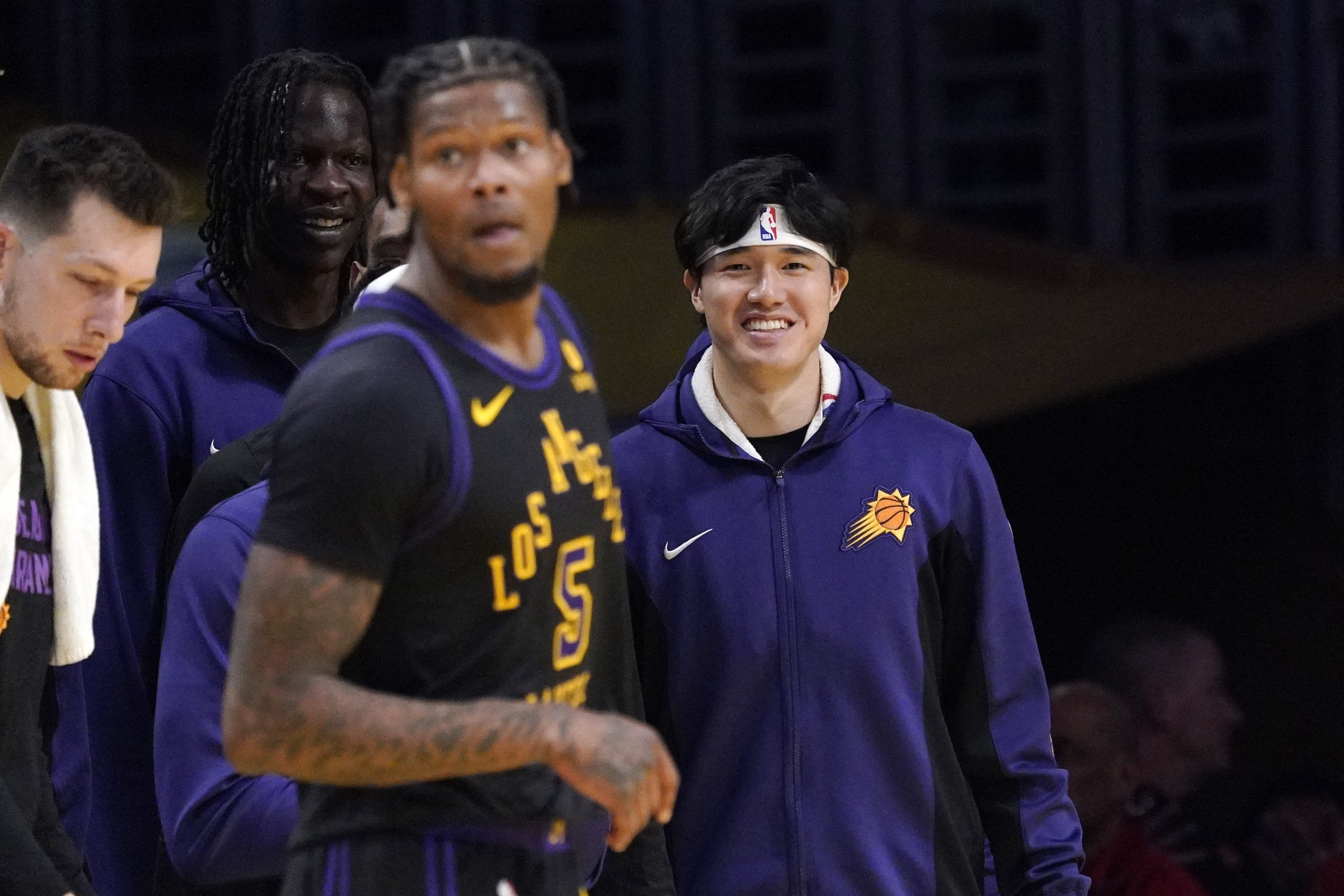 Phoenix Suns forward Yuta Watanabe, right, watches from the bench...