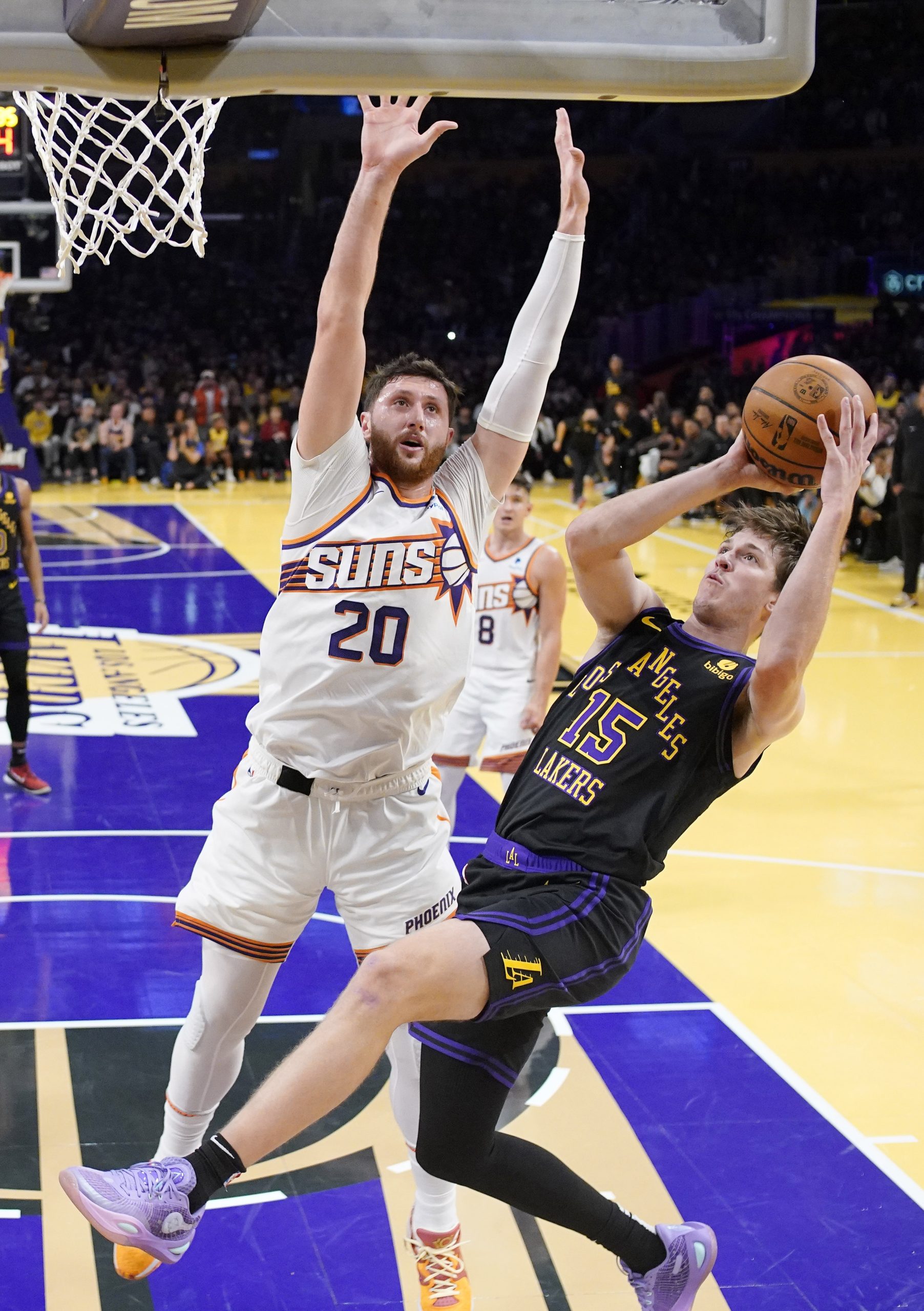 Lakers guard Austin Reaves, right, shoots as Phoenix Suns center...