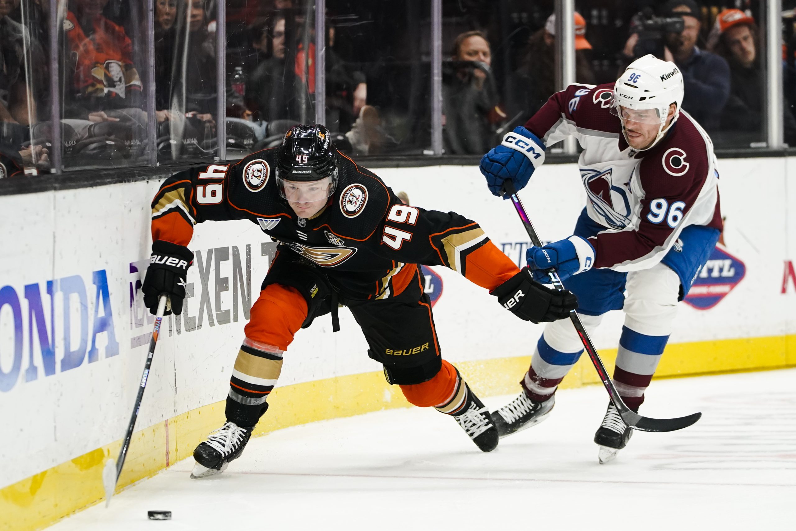 Anaheim Ducks left wing Max Jones, left, fends off Colorado...