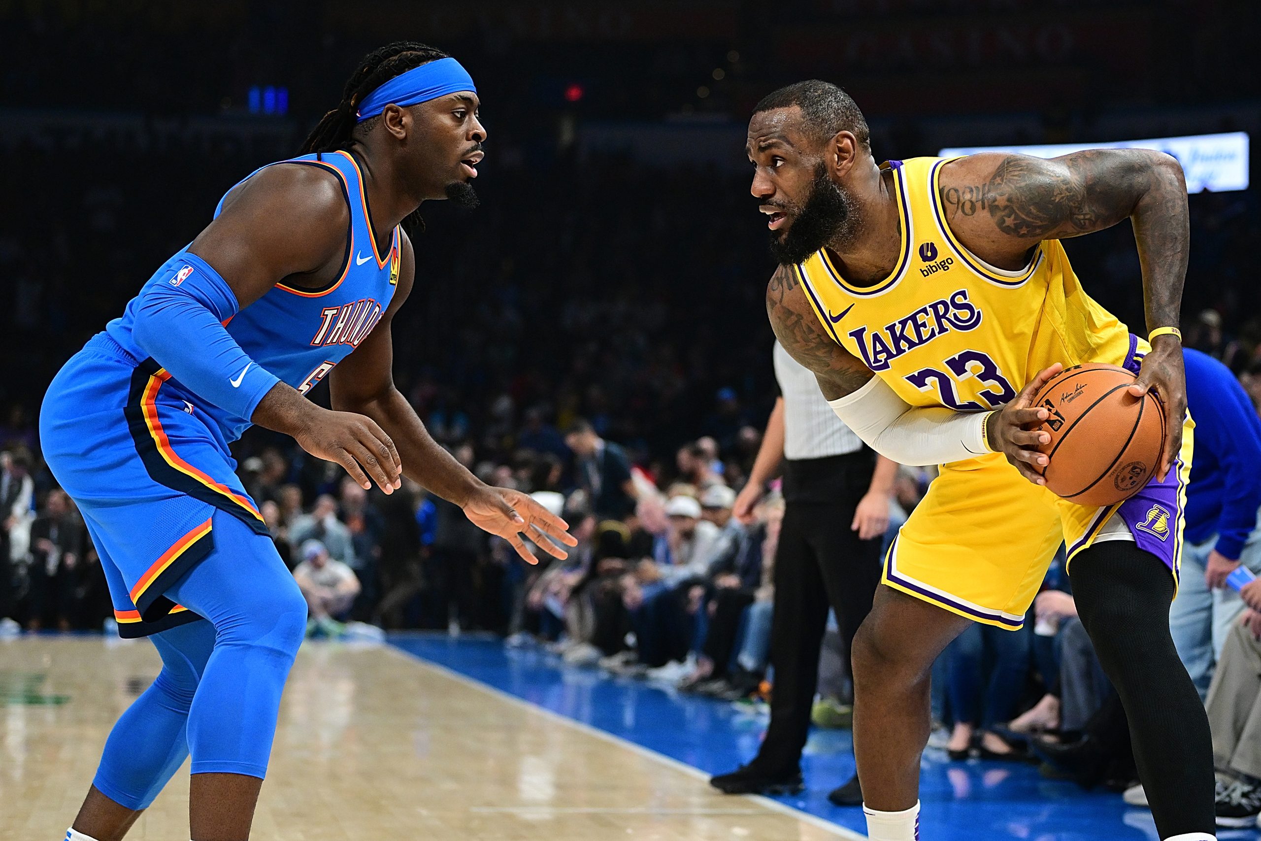 Lakers star Lebron James handles the ball while being defended...