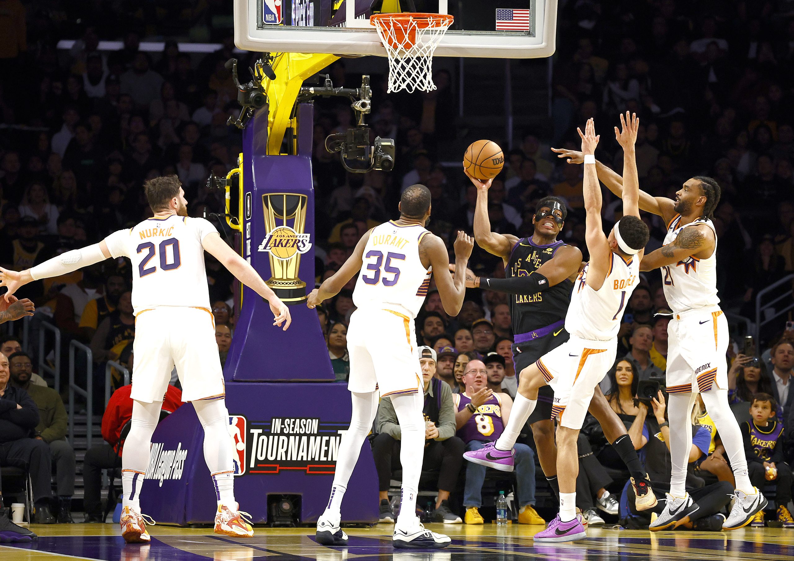 Lakers forward Rui Hachimura passes the ball while under heavy...