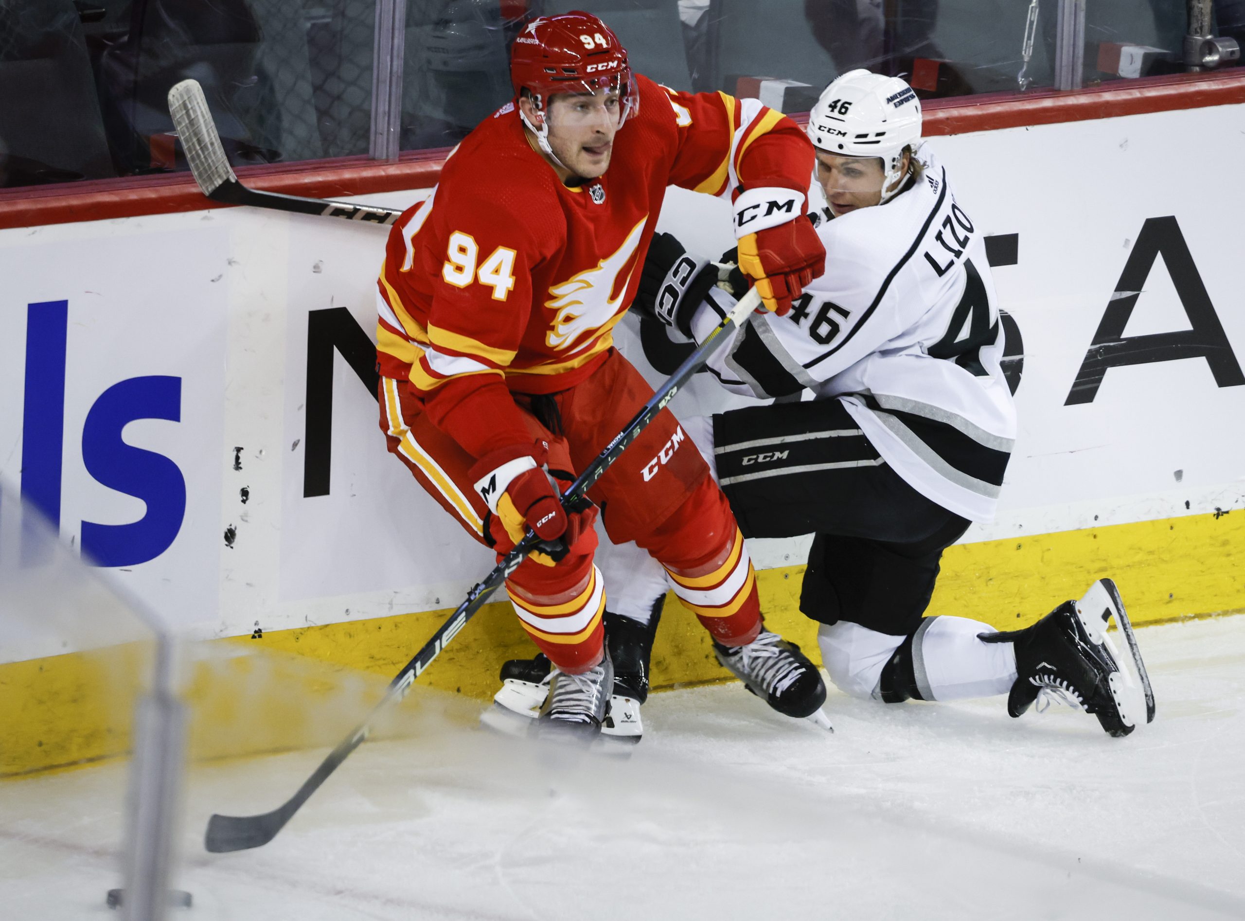 Kings forward Blake Lizotte, right, is checked by Calgary Flames...