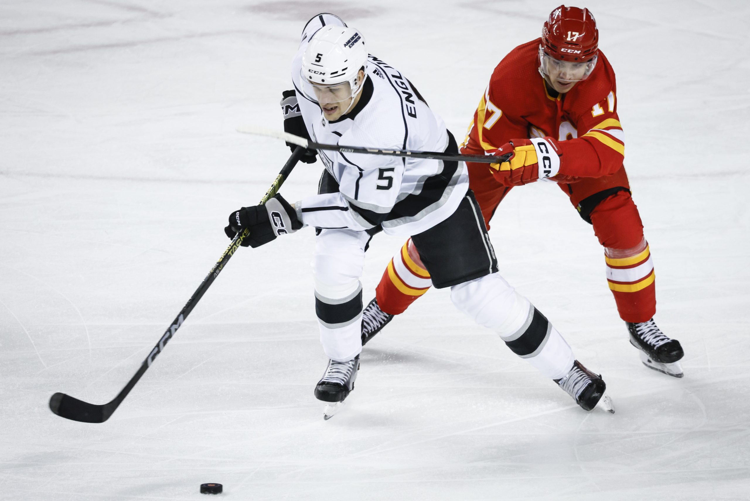 Kings defenseman Andreas Englund, left, is checked by Calgary Flames...