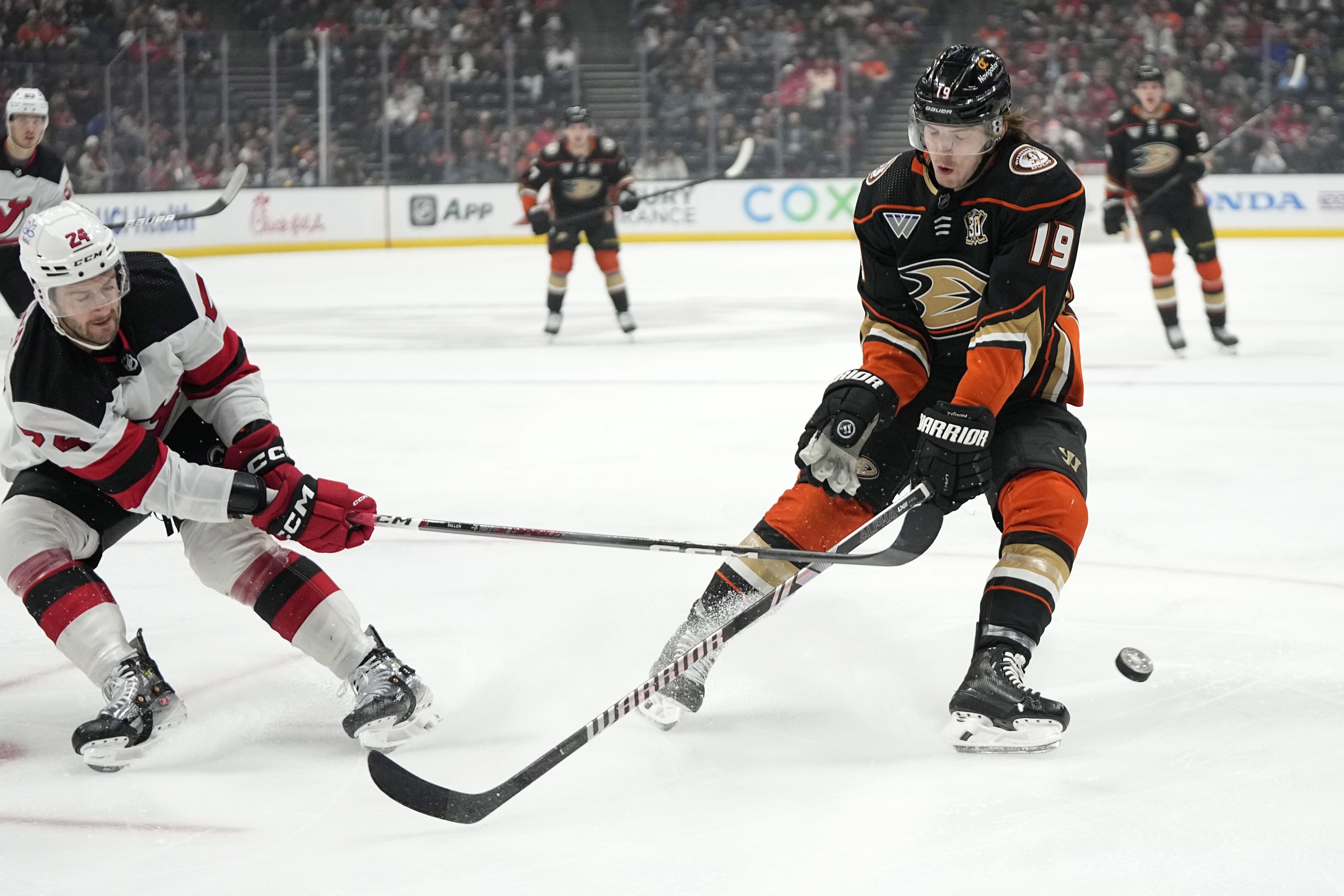 New Jersey Devils defenseman Colin Miller, left, pokes the puck...