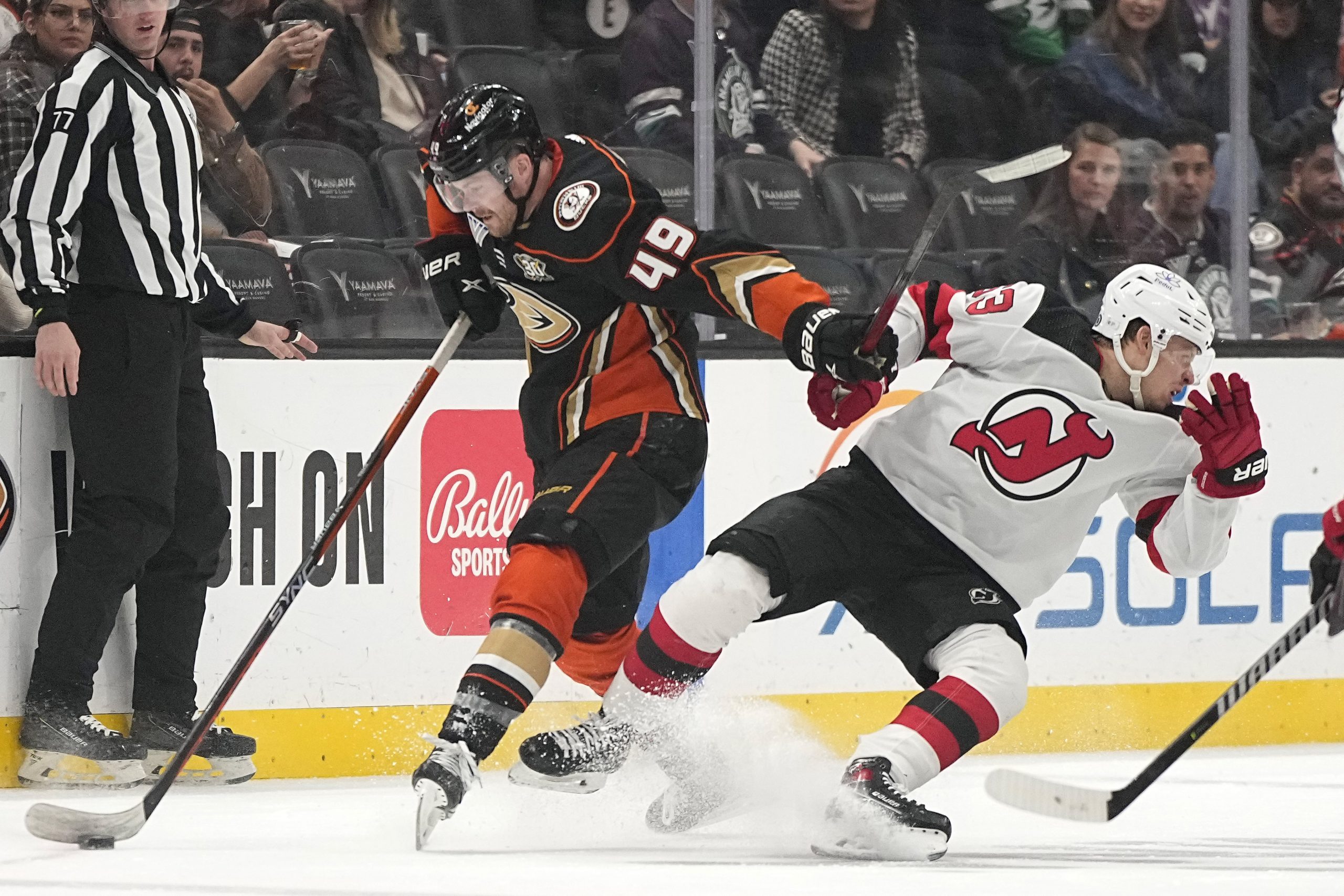 New Jersey Devils left wing Jesper Bratt, right, falls after...