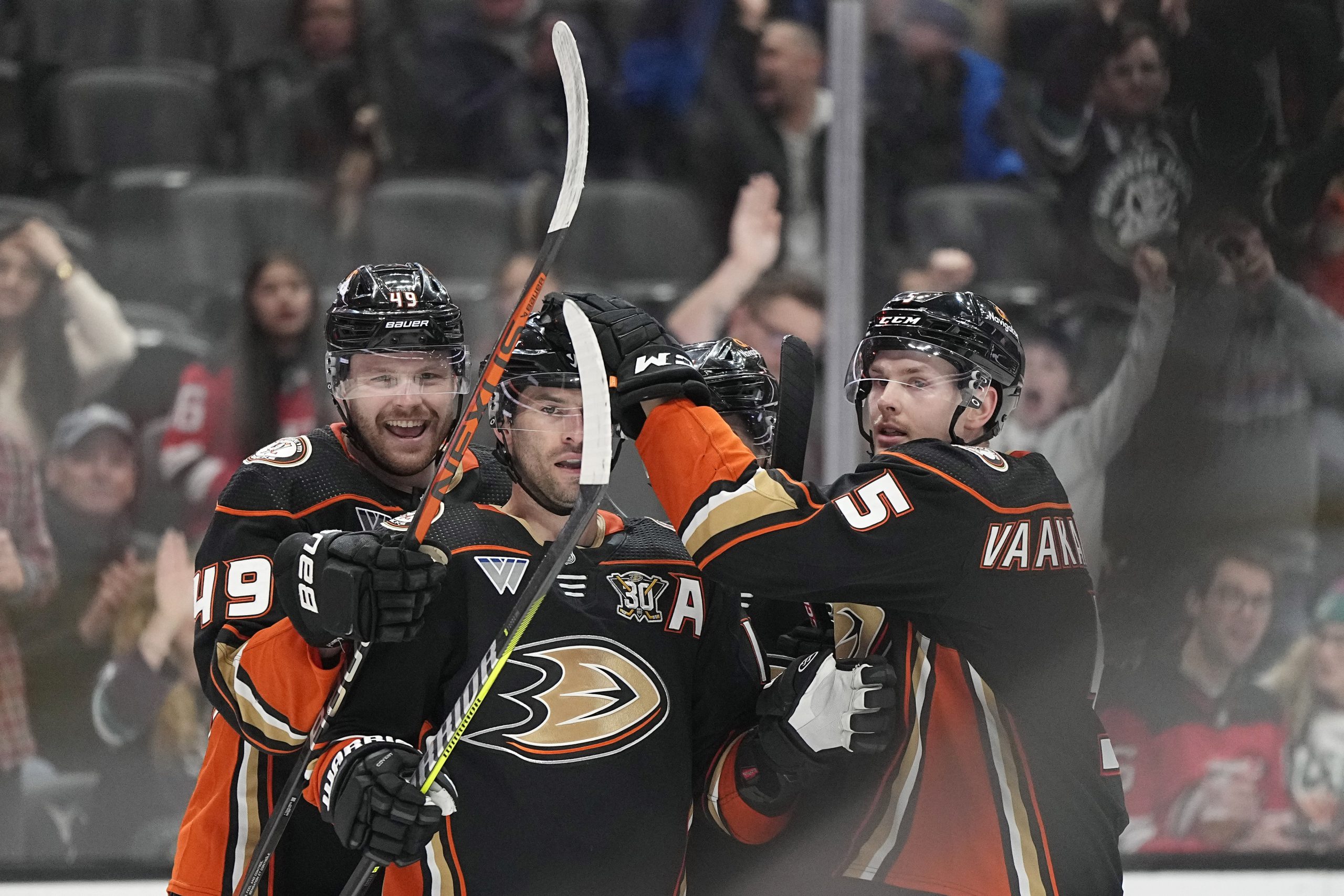 Ducks center Adam Henrique, center, celebrates his goal with left...